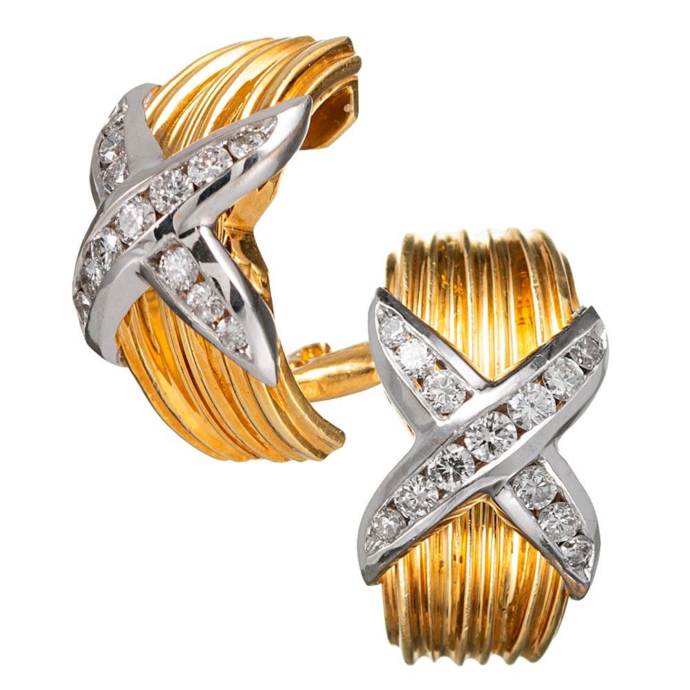 Possibly inspired by the iconic designs of Paloma Picasso or David Yurman, but unsigned, these 18 karat yellow and white gold earrings are decorated with a strong singular design of an X set with .60 carats of diamonds. These are attractive and