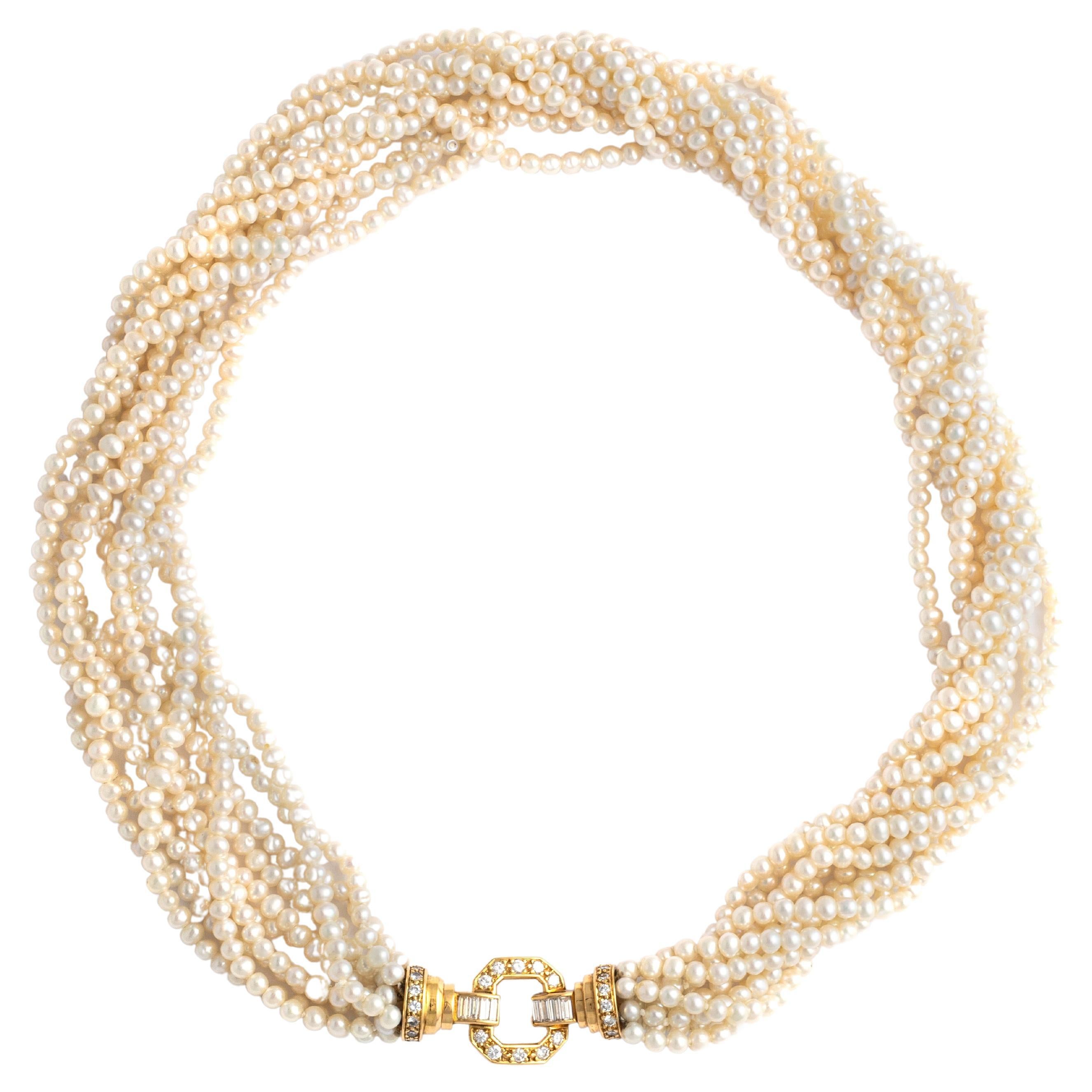 Collier de perles de culture composé de 10 rangs de perles retenant un fermoir en or jaune 18 carats serti de 28 diamants ronds et de 8 diamants baguettes.

Les rangs de perles lustrées créent une cascade luxueuse et volumineuse, encadrant le