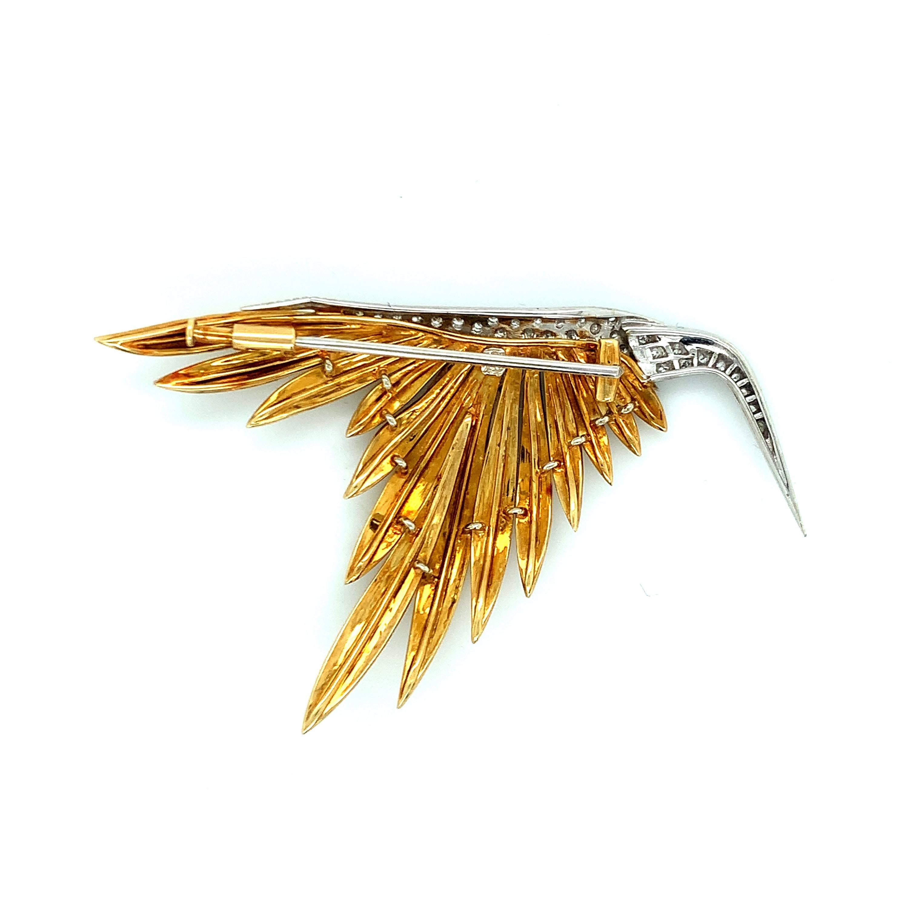 This yellow gold brooch features an abstract figure of a bird in mid-flight. Although the bird is depicted in round diamonds, the attention falls on the beauty of its striking golden feathers. Possibly created by Pierre Sterlé. Total weight: 14.8