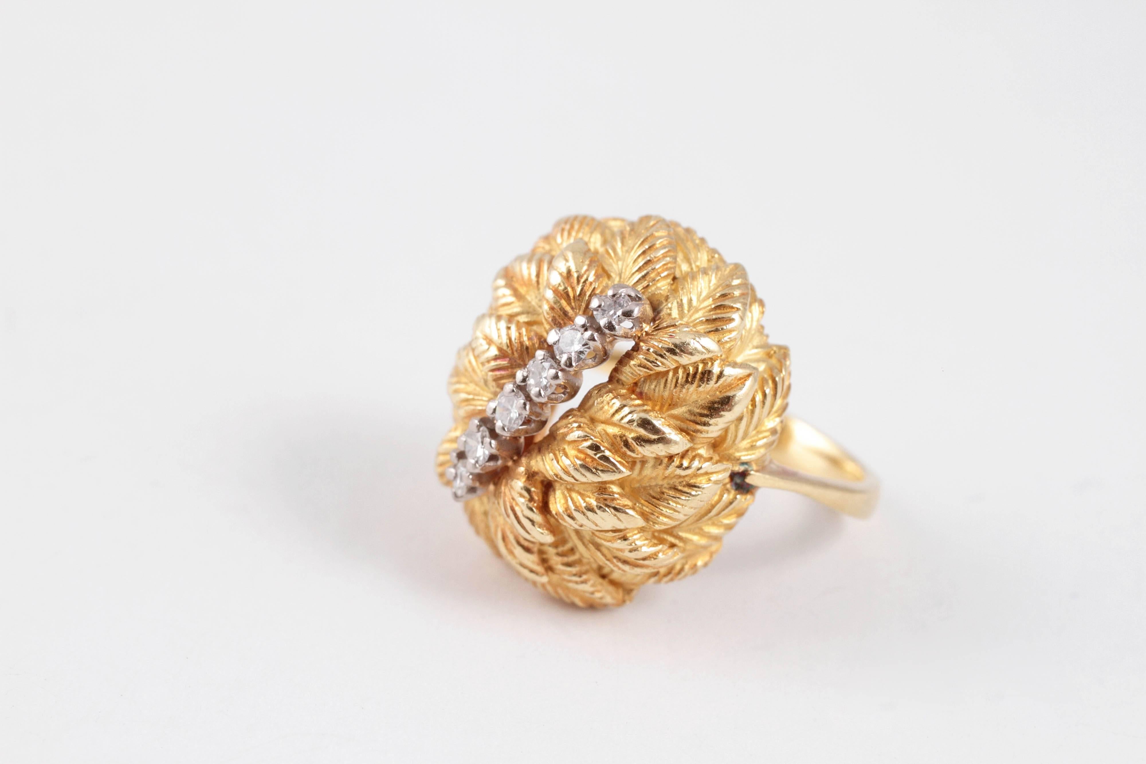 Such a cool retro style!  In 18 karat yellow gold, an overlapping leaf design, with a row of diamonds across the center.  Size 6 1/2. 