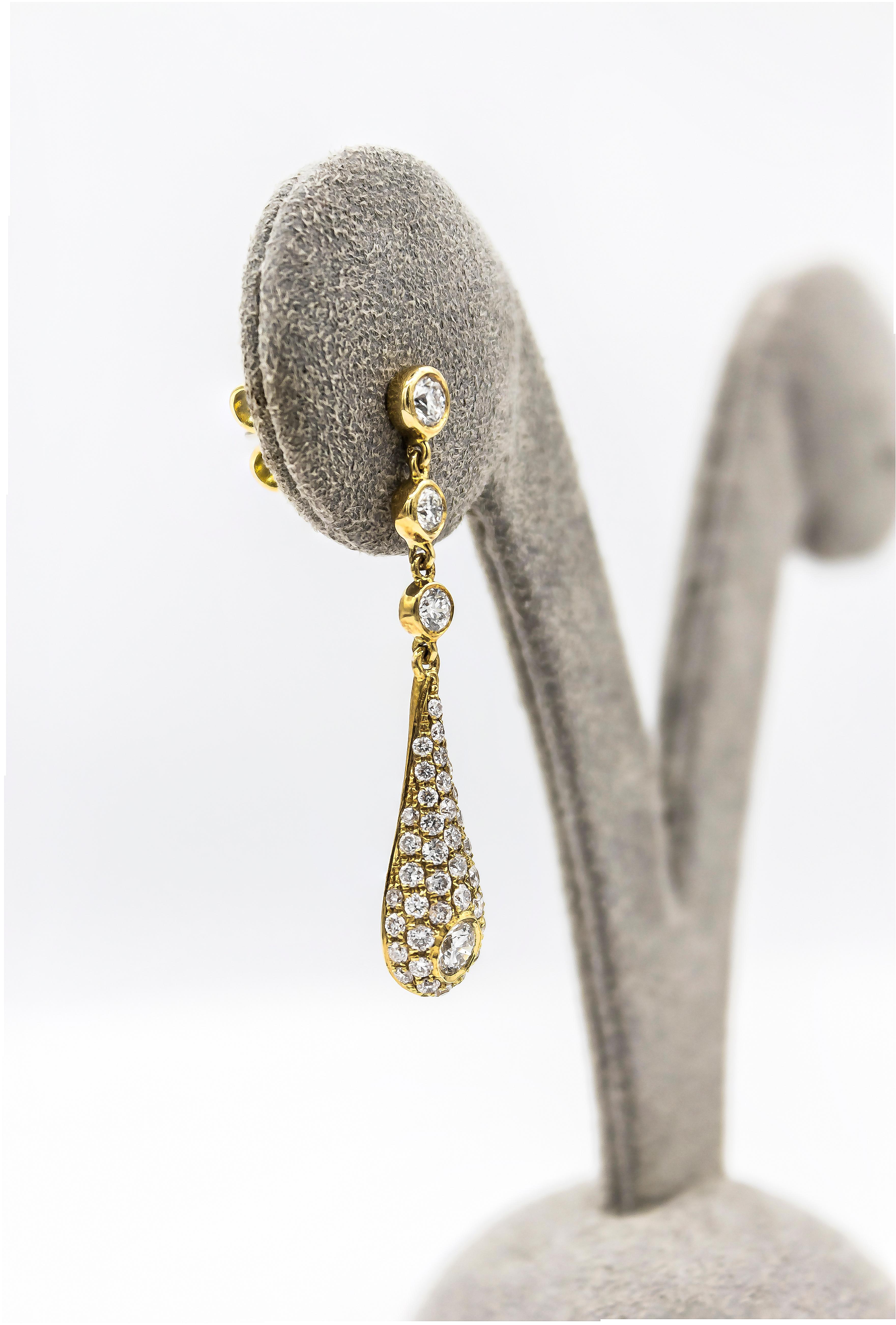 This flattering pair of earrings showcasing a teardrop shape encrusted with round brilliant diamonds. Suspended on three bezel set diamonds. Diamonds weigh 1.74 carats total. Made in 18K Yellow Gold. 

Style available in different price ranges.