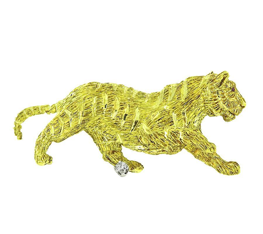 This is an elegant 18k yellow gold tiger pin. The pin is set with sparkling round cut diamond accent. The pin measures 22.5mm by 51mm and weighs 17.3 grams. The pin is stamped 18K.