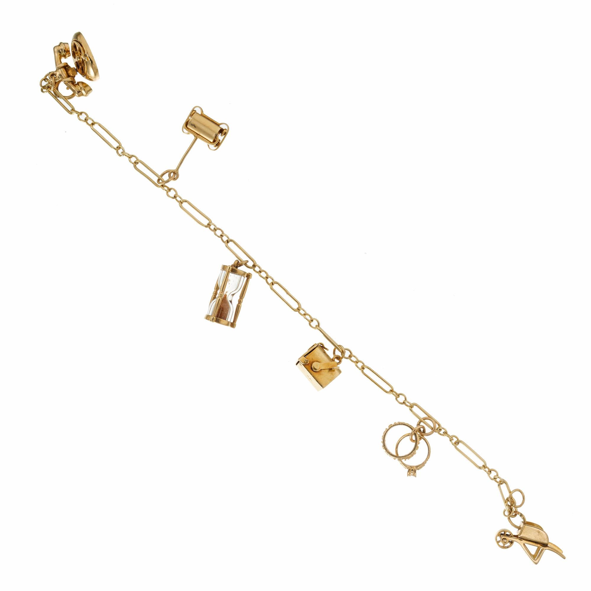 Vintage 1950's 3D charm bracelet with a wheel and barrel, diamond ring set with diamond, mailbox, hour glass, sweeper and telephone. Charms and bracelet all 14k gold. 7.25 inches in length. 

1 single cut diamond, G VS approx. .2cts
14k yellow gold