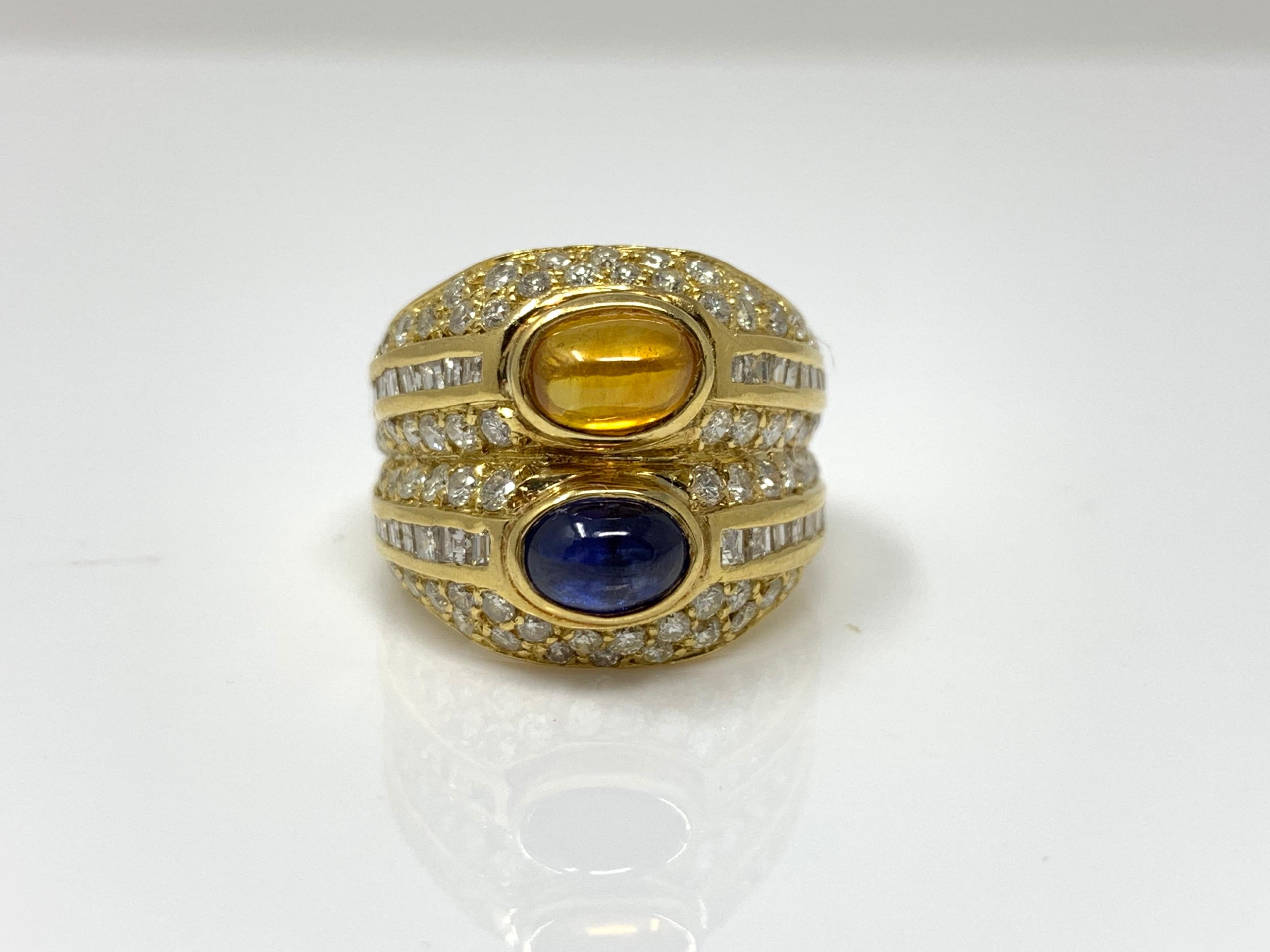 This bold and beautiful ring was wonderfully designed and masterfully handcrafted in 18k yellow gold. The ring is set with two cabochons blue sapphire and yellow sapphire weighing 2 carat , small white diamonds weighing 2.20 carat with SI clarity