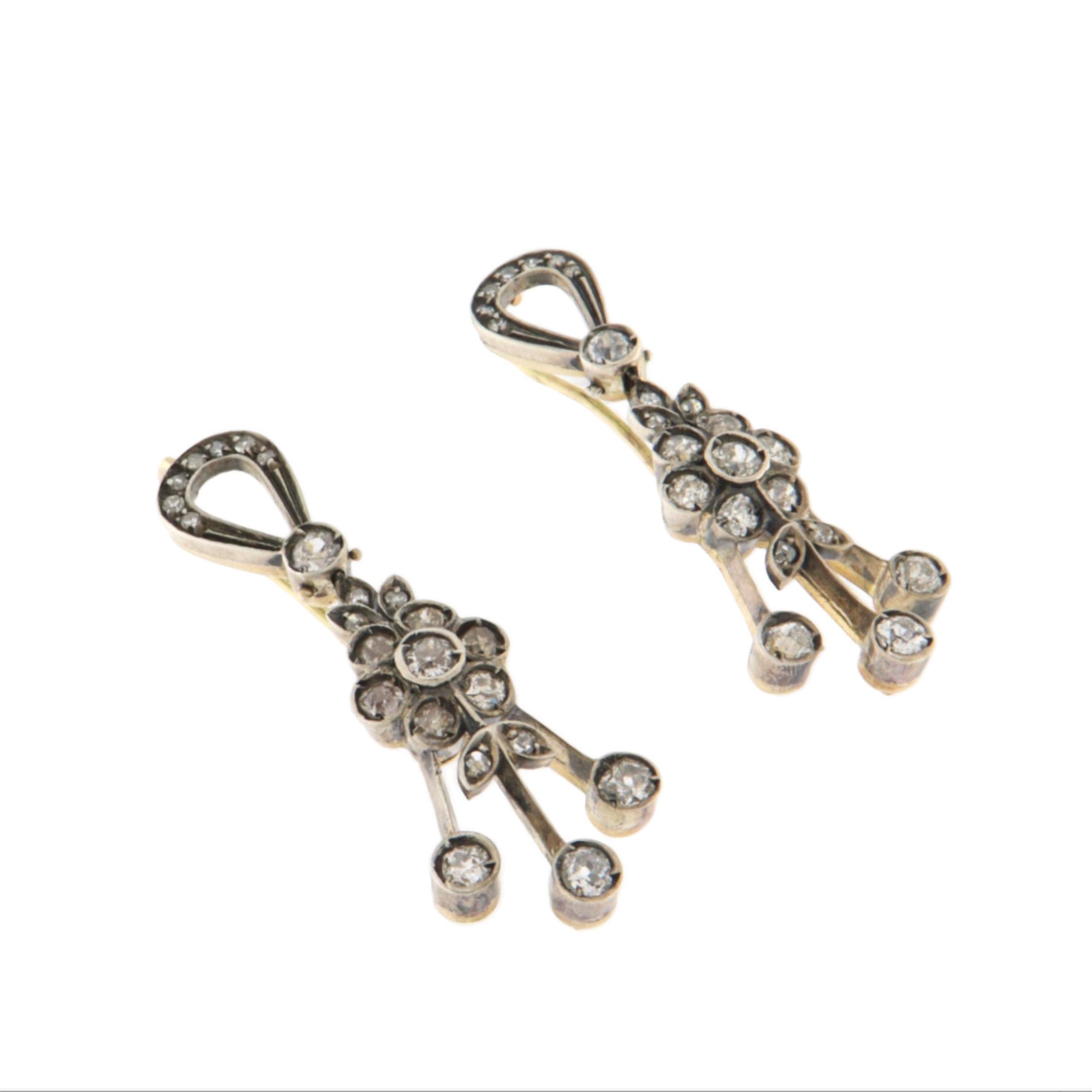 Nous vous présentons une paire de boucles d'oreilles vintage raffinées, élaborées à partir d'une combinaison de matériaux précieux avec un design floral sophistiqué. Ces boucles d'oreilles sont réalisées en or jaune 14 carats et en argent 800