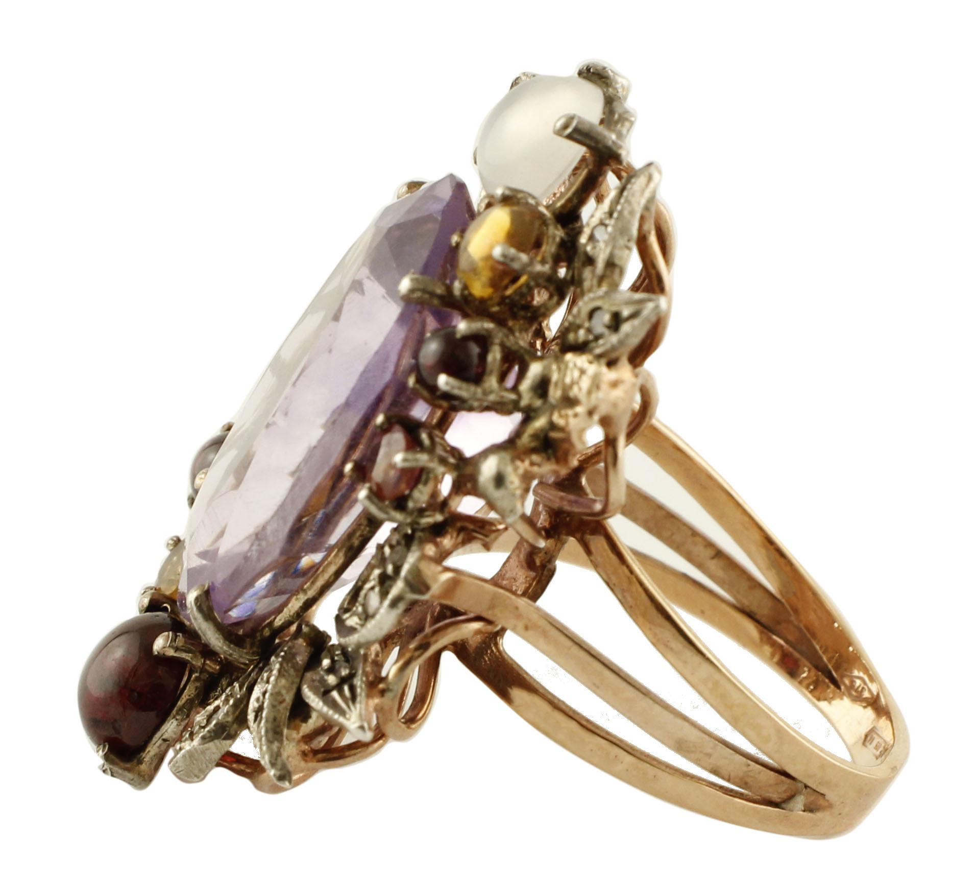 Unique retrò ring in 9K rose gold and silver structure composed of big amethyst (20 mm X 15 mm) in the center surrounded by yellow topazes, garnets, moonstone and it's embellished by leaves detailes studded by little diamonds. 
Diamonds 0.13 ct