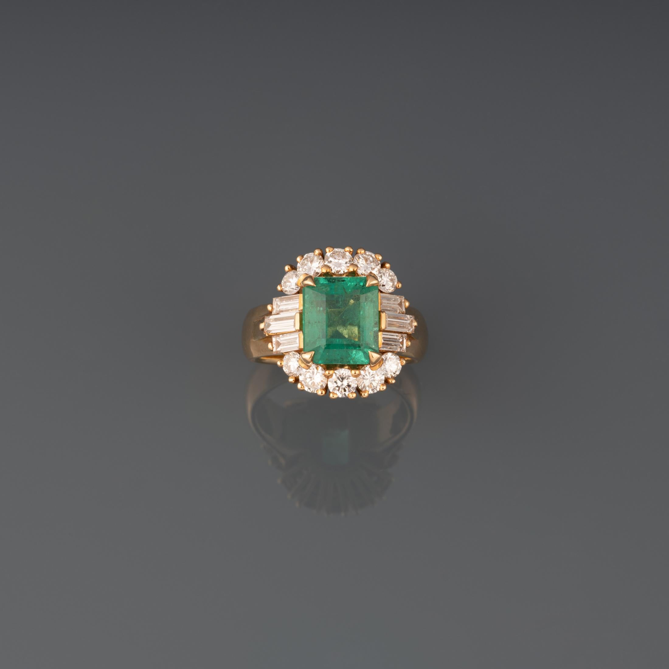 A beautiful ring, made by great house Mouawad. 

Made in yellow gold 18k, set with quality diamonds and a beautiful emerald certified from Zambia. The diamonds weights 1.20 carats approximately.

The emerald has a good clarity and weights 3.58