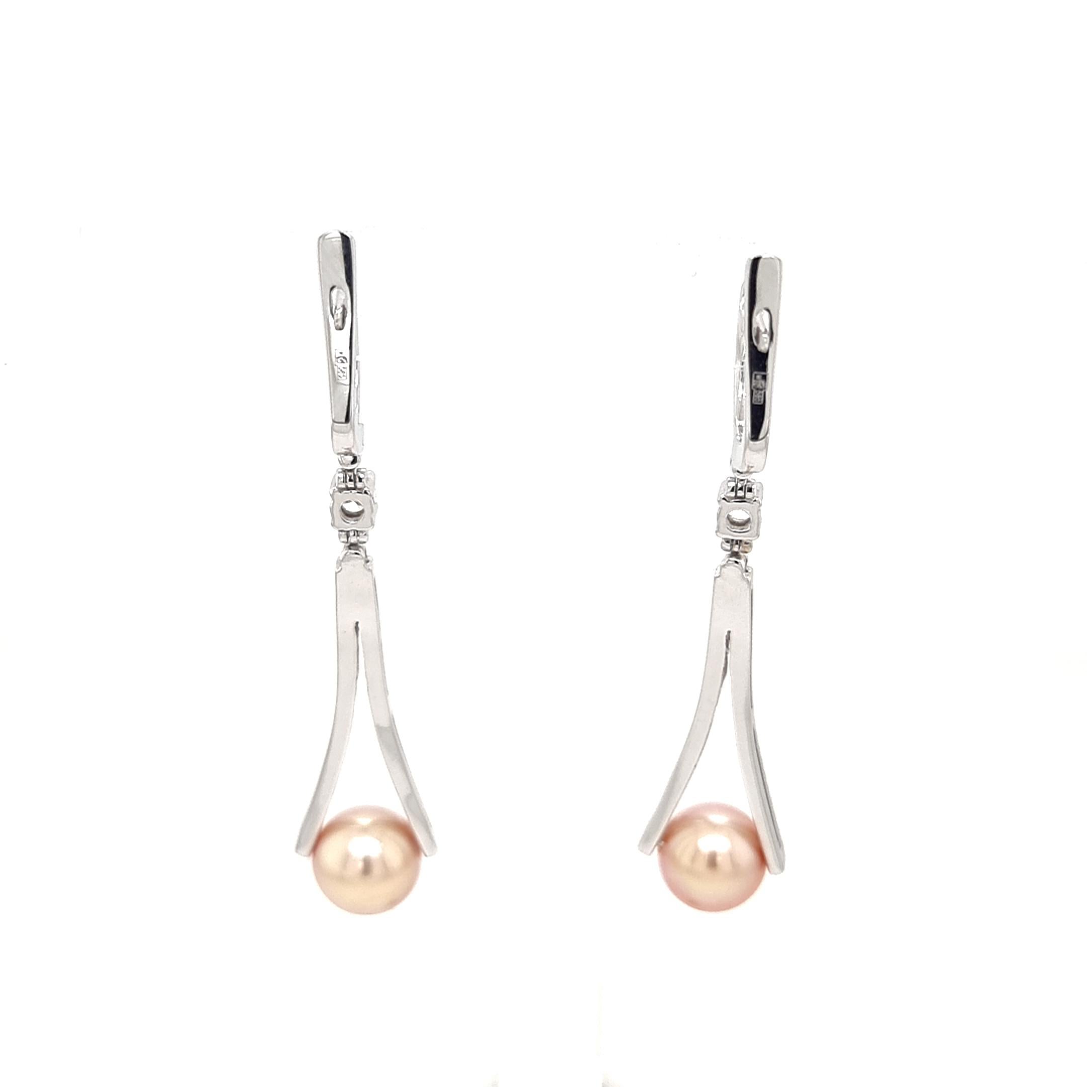 Welcome to a world of eternal elegance where sophistication meets allure. Embrace the captivating charm of our 14K white gold earrings, gracefully adorned with dazzling white round diamonds and lustrous cultured pearls, each measuring 8.50 mm. As