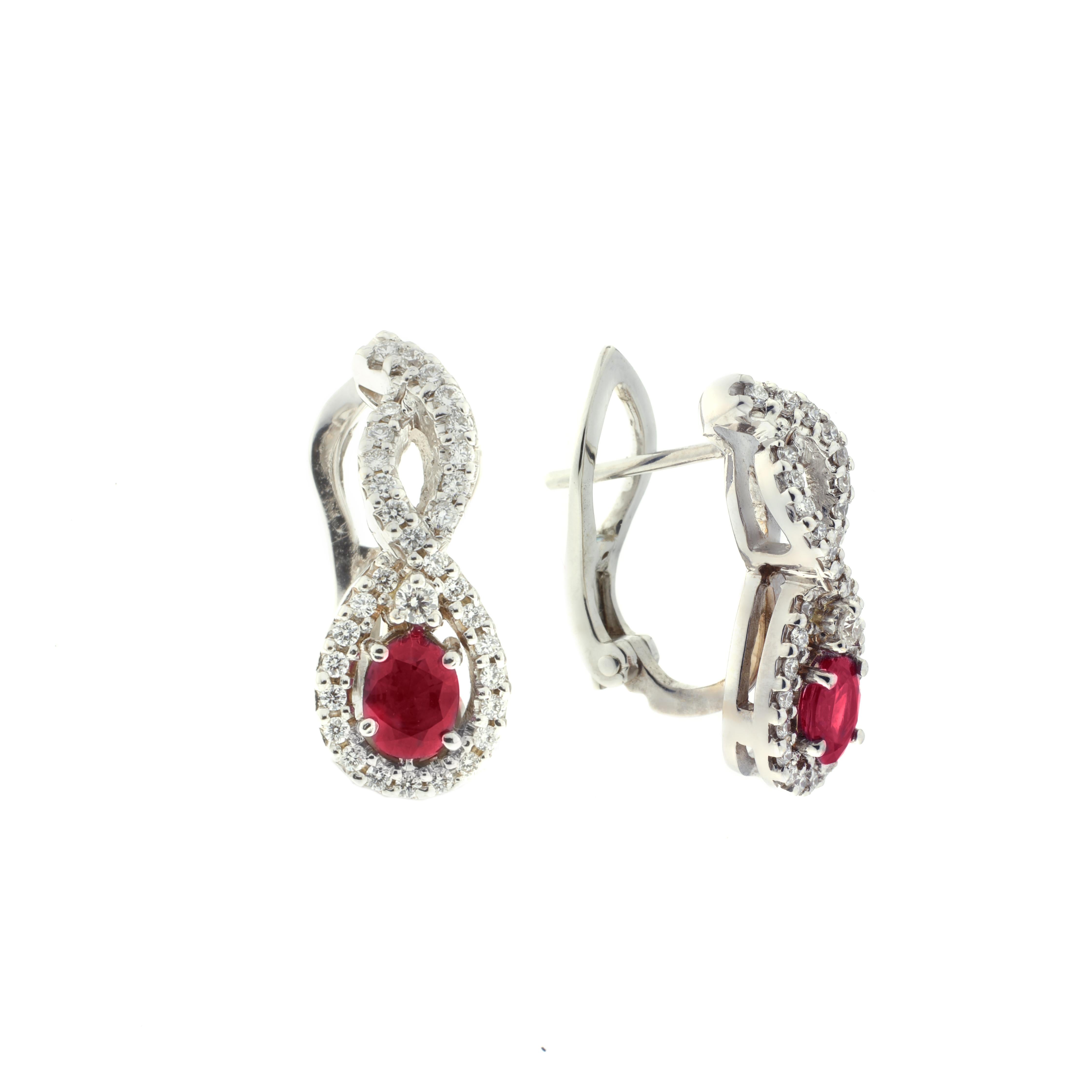 These earrings, masterfully created entirely by hand from 18-karat white gold, are each set with a vibrant ruby set amongst brilliant white diamonds. The stylized figure-of-eight design is evocative of classic symbols of eternity and