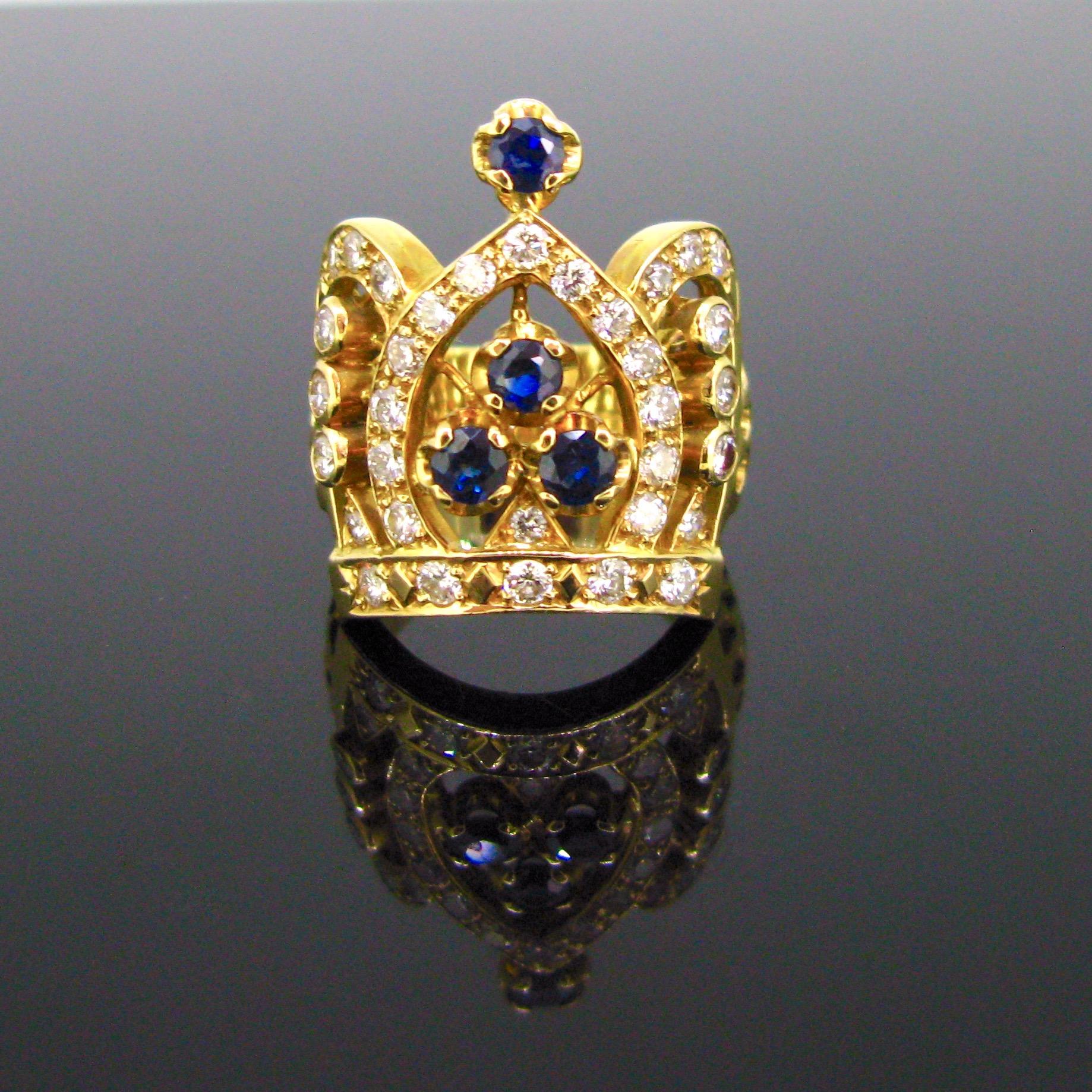 This ring is designed as a Crown.  It is set with 4 sapphires and adorned with brilliant cut diamonds. The ring is fully made in 18kt yellow gold.  It is controlled with the UK hallmarks.

Weight:	14gr

Circa:	Modern

Metal:	18kt yellow gold