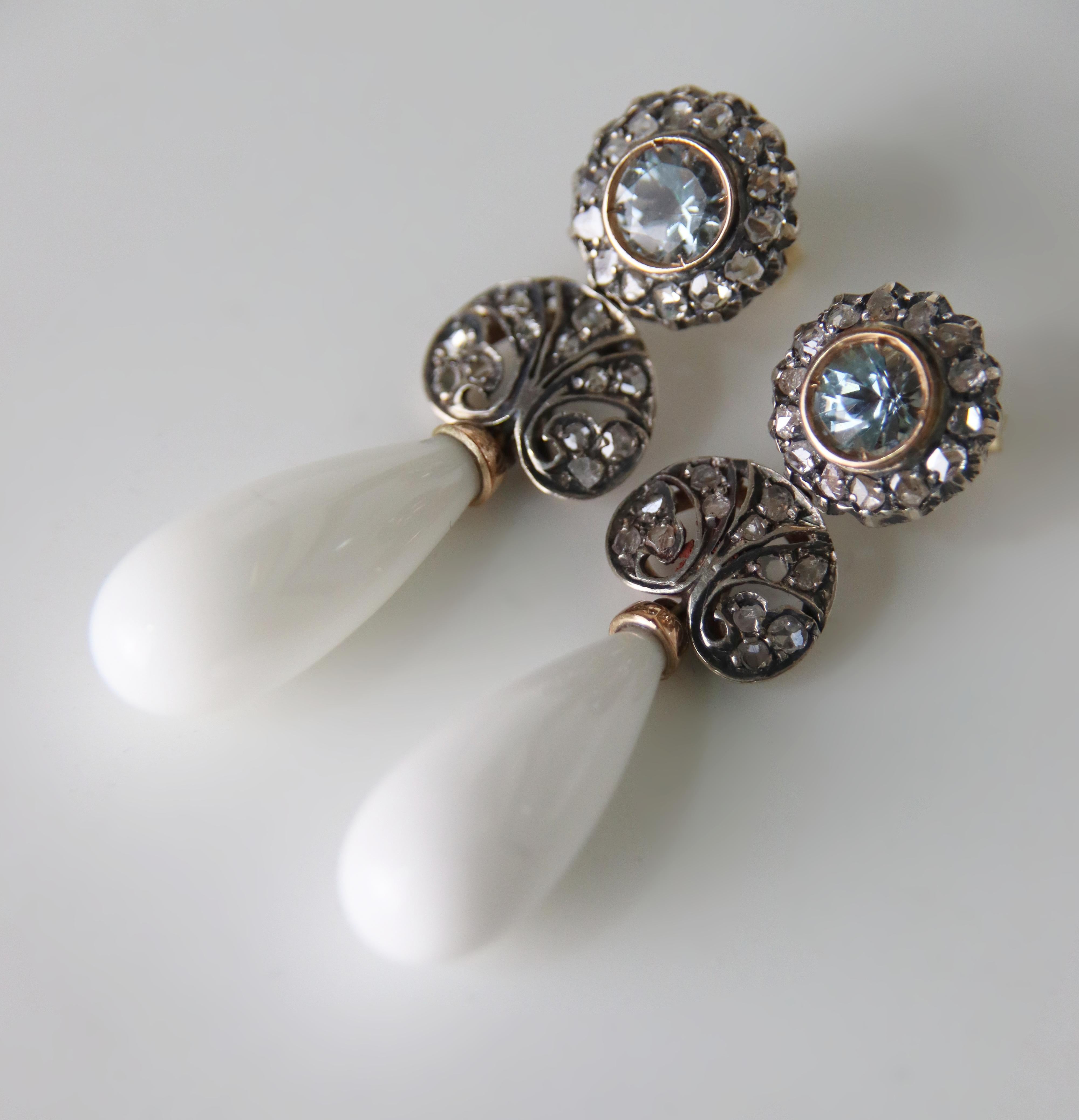 Ces exquises boucles d'oreilles en or jaune 14 carats et en argent 800 millièmes sont un parfait exemple de bijoux anciens, où l'élégance classique rencontre un équilibre raffiné de matériaux et de pierres précieuses. Le design, réalisé avec une