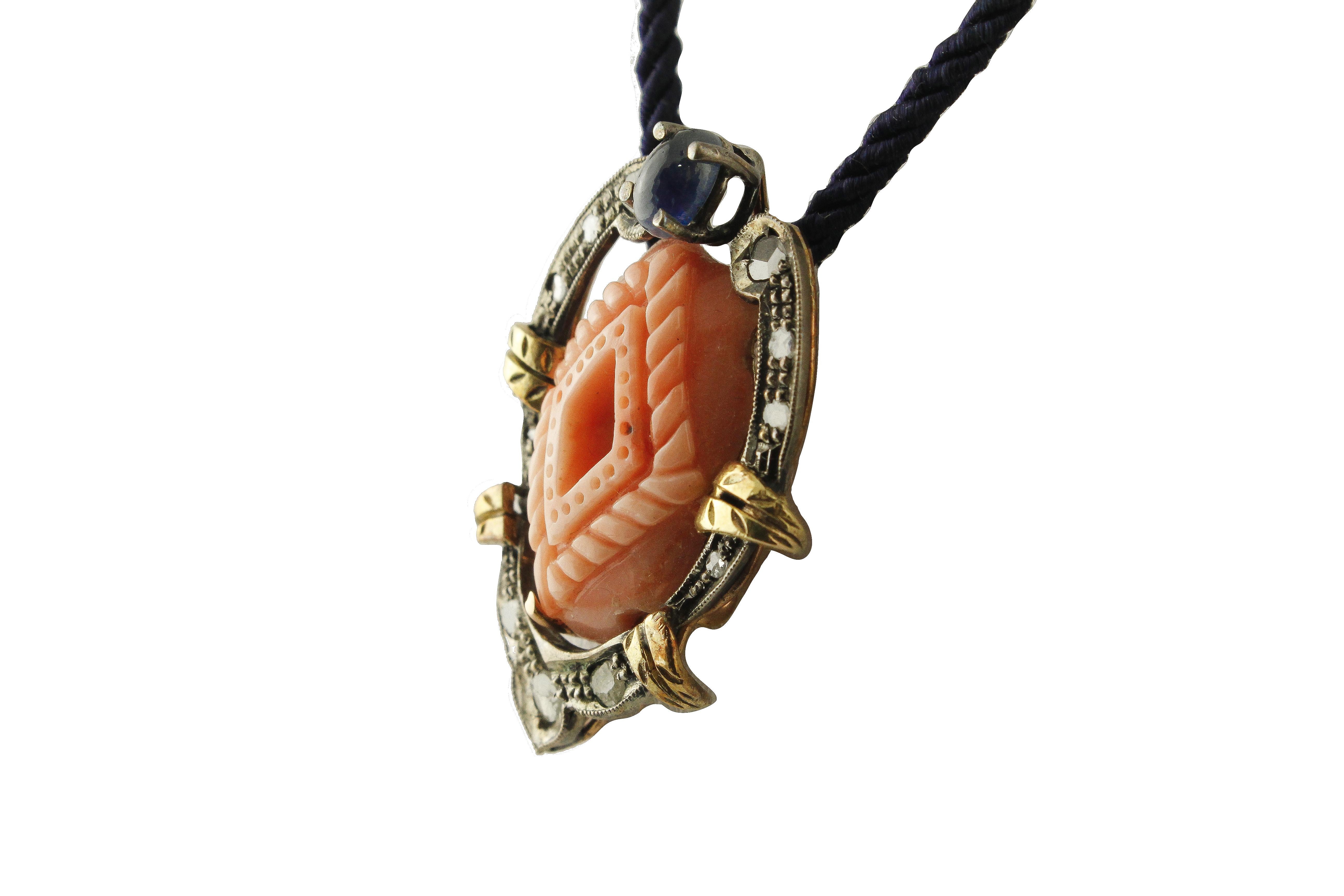 Fashion pendant necklace/ brooch in 14K rose and yellow gold and silver structure composed of a blue sapphire at the top, carved coral in the center surrounded by diamonds and yellow gold leaves detailes
(the chain is only to make photos)
Diamonds