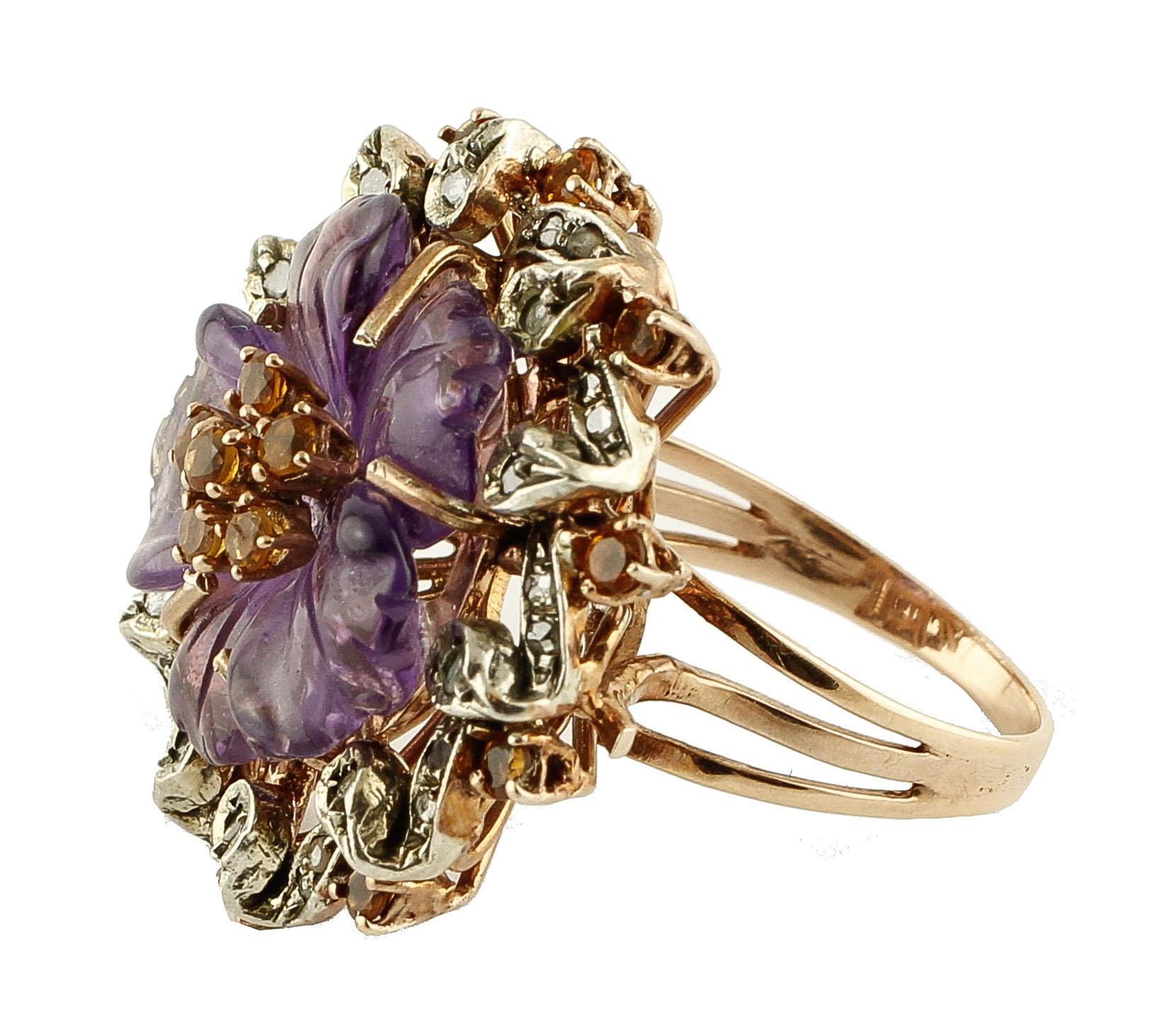 Amazing ring in 9 kt rose gold and silver, 2.8 cm in diameter, embellished with a central amethyst of 1.80 g, 0.38 ct of diamonds and 0.73 ct of blue sapphires. 
Diamond ct 0.38
Blue Sapphire ct 0.73
Amethyst g 1.80
Italian size 17
French size