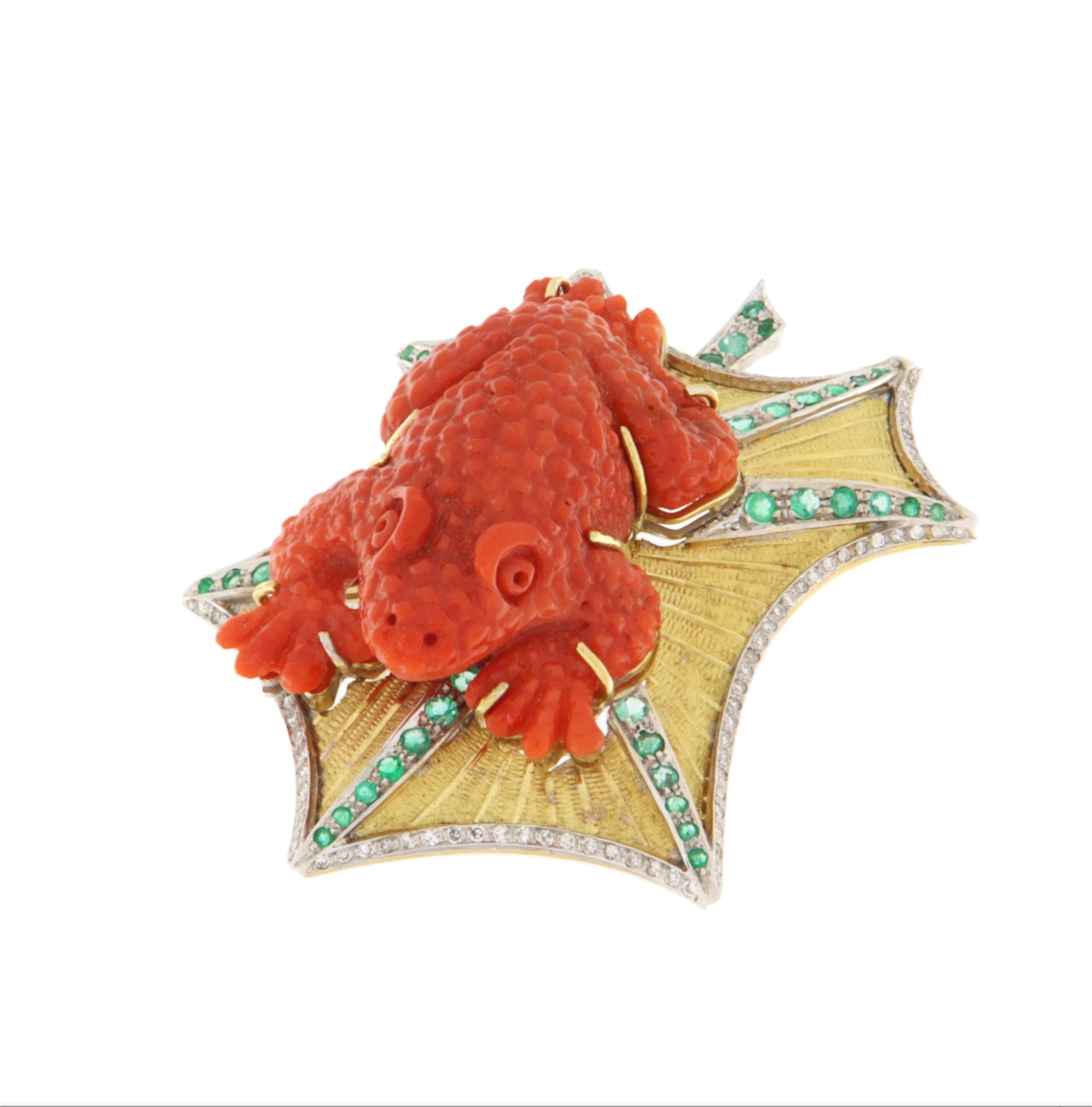 This stunning frog-shaped brooch is a true masterpiece of fine jewelry, crafted in 18K yellow and white gold with exceptional attention to detail. The focal point of this jewel is the body of the frog, carved from natural coral, a precious organic