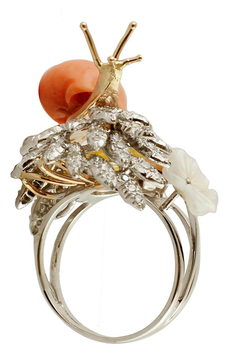 Particular snail ring in 14k white gold structure, set with a lovely snail realized in 14k yellow gold and an elatius coral shell, and flowery details of diamonds and mother-of-pearl.
This unique ring was realized in Italy, totally handmade by