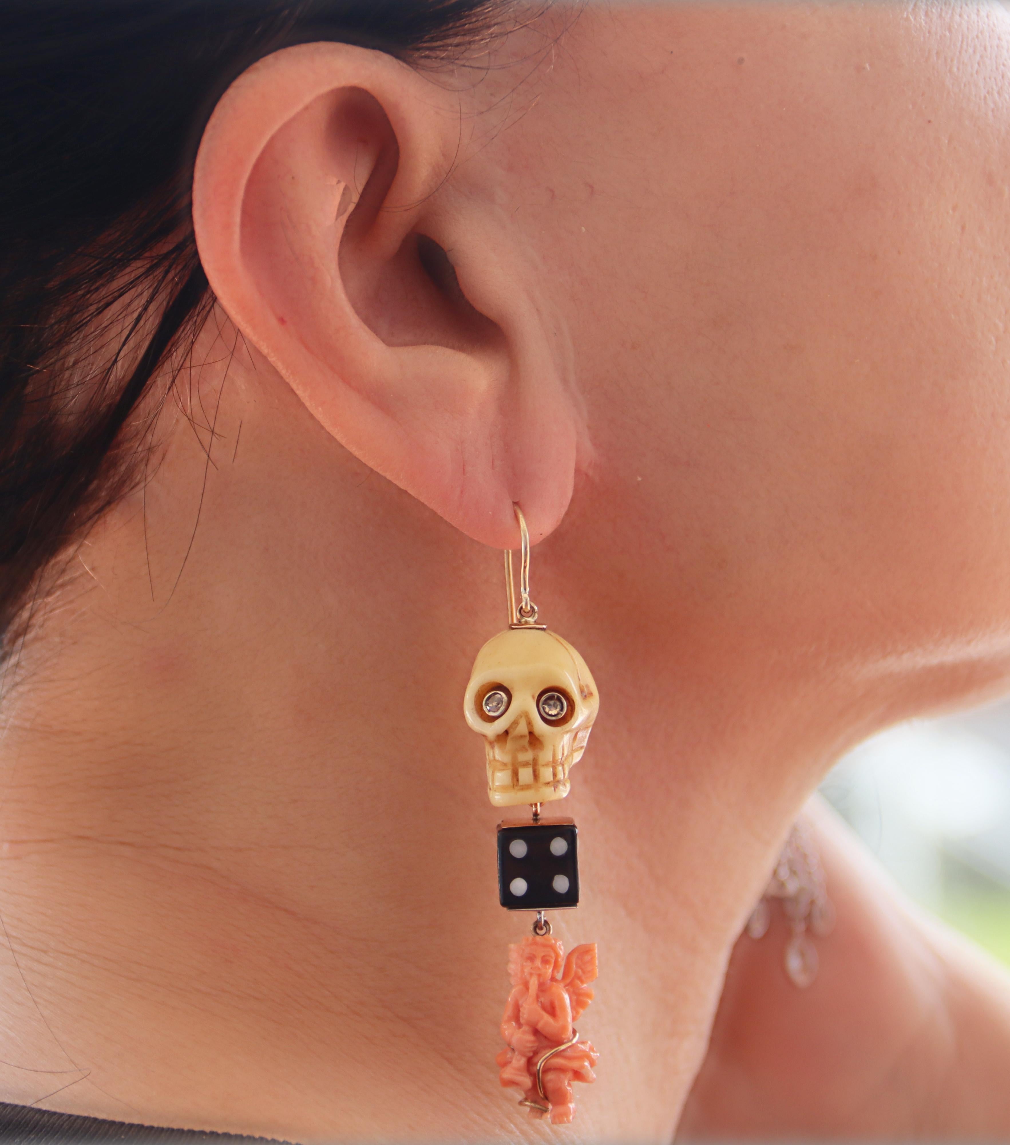 Diese unverwechselbaren Ohrringe vereinen die zeitlose Eleganz von 14-karätigem Gelbgold mit dem einzigartigen Charme von Knochen, Onyx und Koralle. Jeder Ohrring zeigt einen kunstvoll geschnitzten Knochenschädel, dessen raffinierte Schärfe durch
