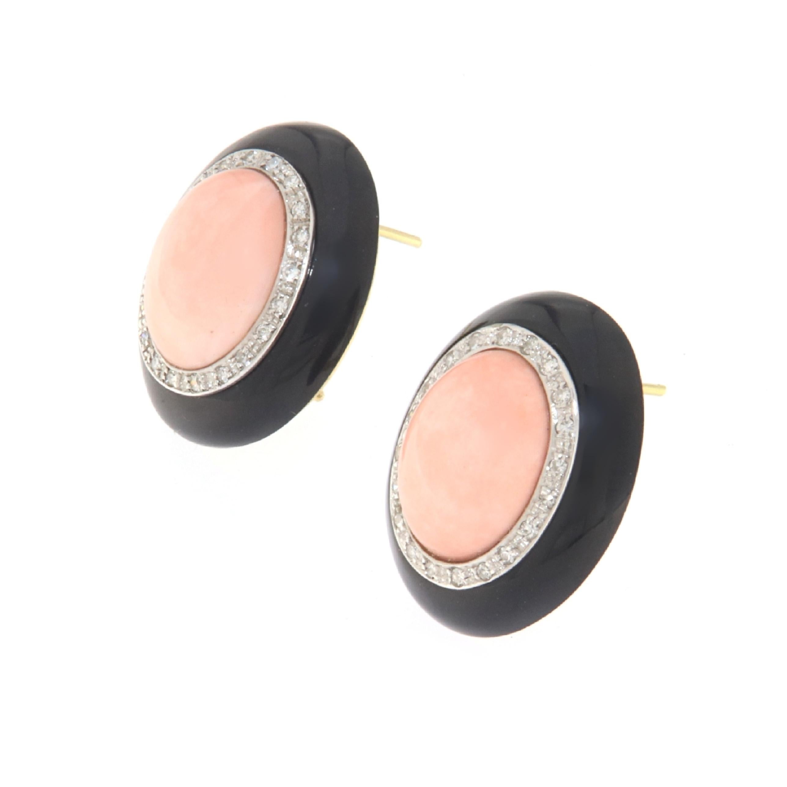 These chic earrings are a masterful display of luxury, meticulously crafted from 18-karat white and yellow gold. Each earring is adorned with a central piece of soft-hued coral, set against a striking backdrop of glossy black onyx. The coral inserts