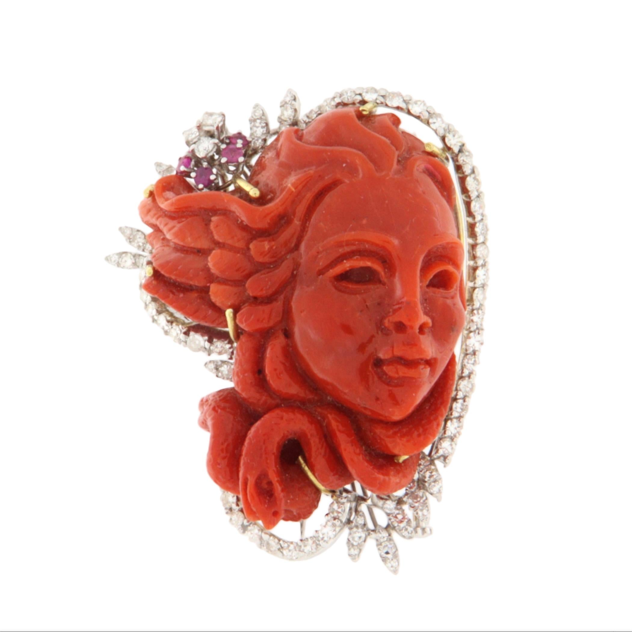 Cette broche en forme de camée est la fusion parfaite de l'artisanat sculptural et de la conception de bijoux haut de gamme. La pièce maîtresse est un visage de femme finement sculpté à la main dans du corail rouge authentique, avec une habileté