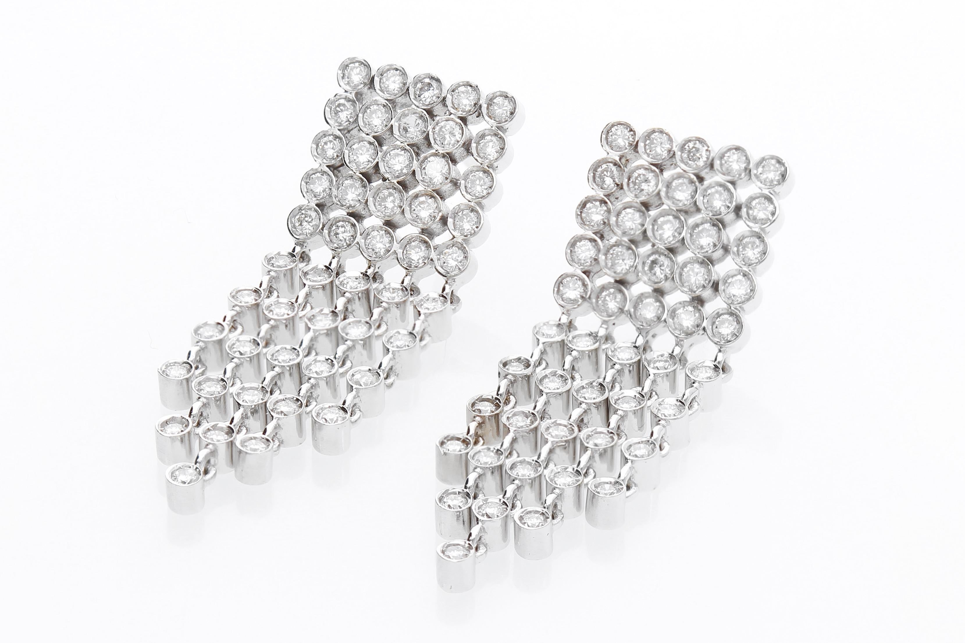 Gli orecchini sono formati da un quadrato con diamanti da cui partono cinque catene con 85 diamanti incastonati. Il peso totale dei diamanti è di 1,85 ct. 
Gli orecchini sono in oro bianco 18 Kt. 
La lavorazione è Made in Italy.

Peso totale dei