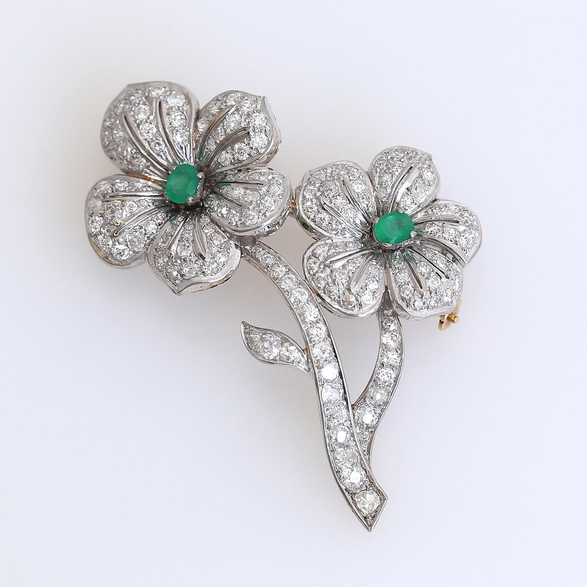 Diamonds Emeralds Flower Brooch 18 Karat White Gold, 1970

Flowers brooch comprised of Diamonds all throughout the composition and two Emeralds in the centre. The outstanding craftsmanship of a jeweler with fine work on both sides of the brooch. 18