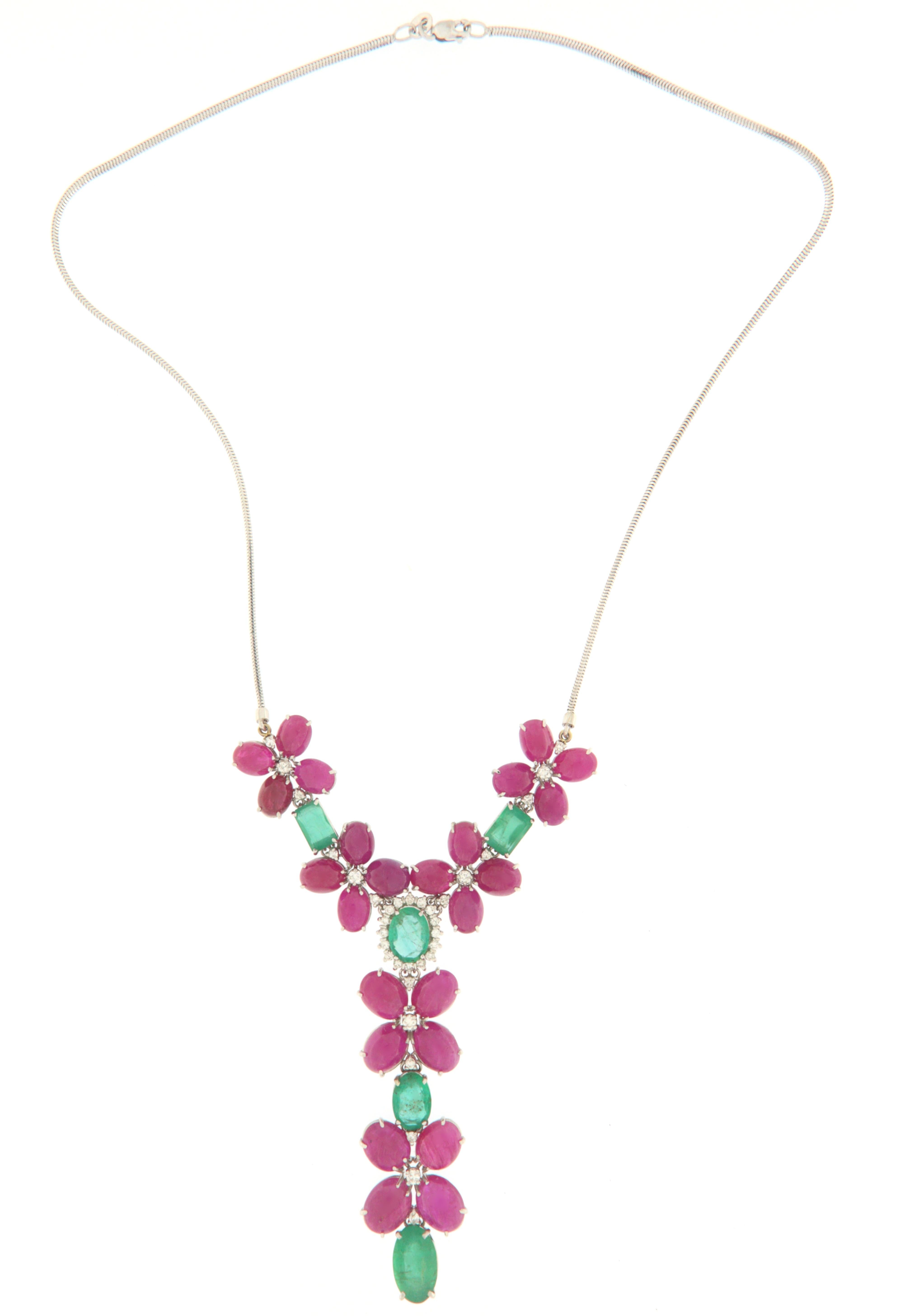 Precious necklace made entirely by hand by skilled Neapolitan goldsmiths, the drawn shapes look like flowers, made of 18-karat white gold featuring oval cabochon-cut rubies, emeralds in different shapes (rectangular and oval) of Brazilian origin and