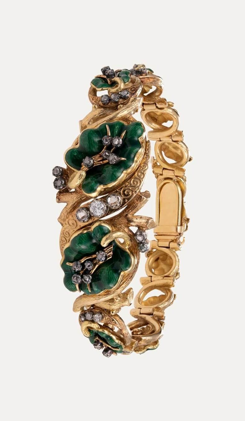 Brilliante in oro giallo 19,2kt - 800‰, con 36 diamanti taglio rosa, foglie verdi smaltate e 1 brillante al centro con circa 0,14ct. Con catena di sicurezza.