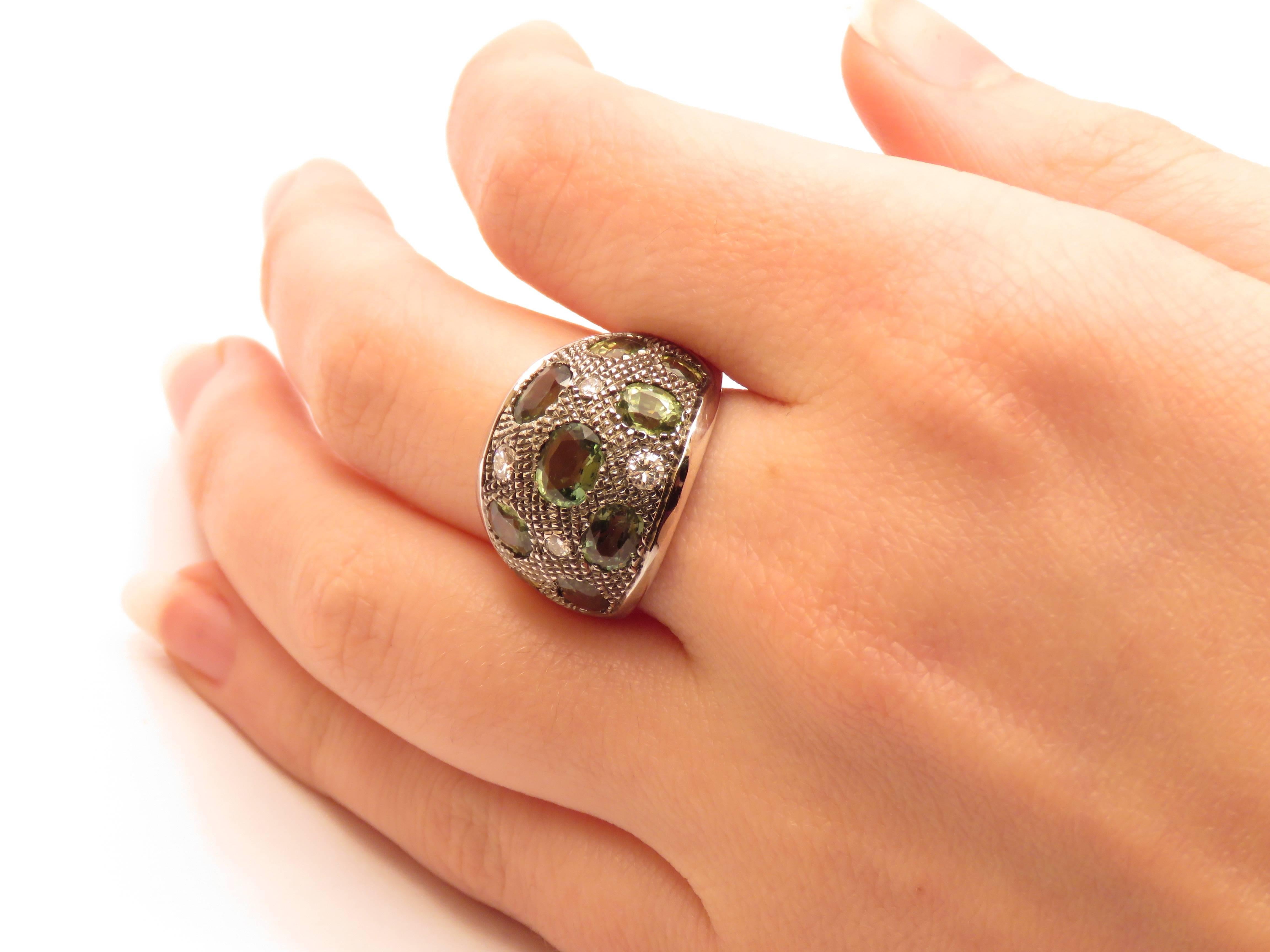 Jolie bague en or blanc 18 carats ornée de neuf saphirs verts ovales et de quatre diamants. Les saphirs verts ovales représentent 4,10 ctw et les quatre diamants couleur F pureté VS1 représentent 0,25 ctw. Le poids total de la bague est de 10