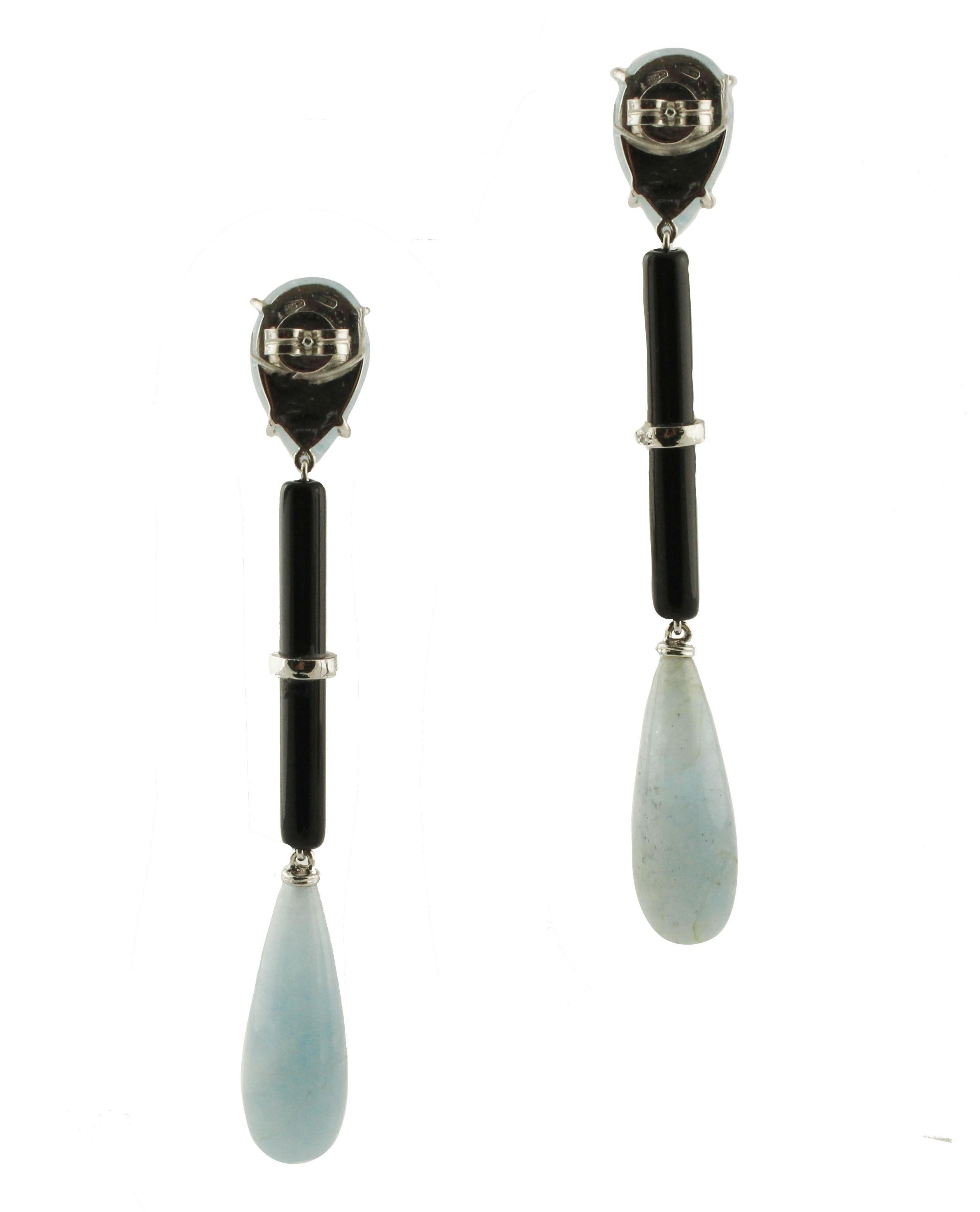 Simple and elegant drop earrings composed of amazing milk aquamarine drops (1.6 cm X 1 cm) at the top, in the middle there are long onyx tubes with 14K white gold hoops in the center studded by diamonds, and to finish at the buttom long milk