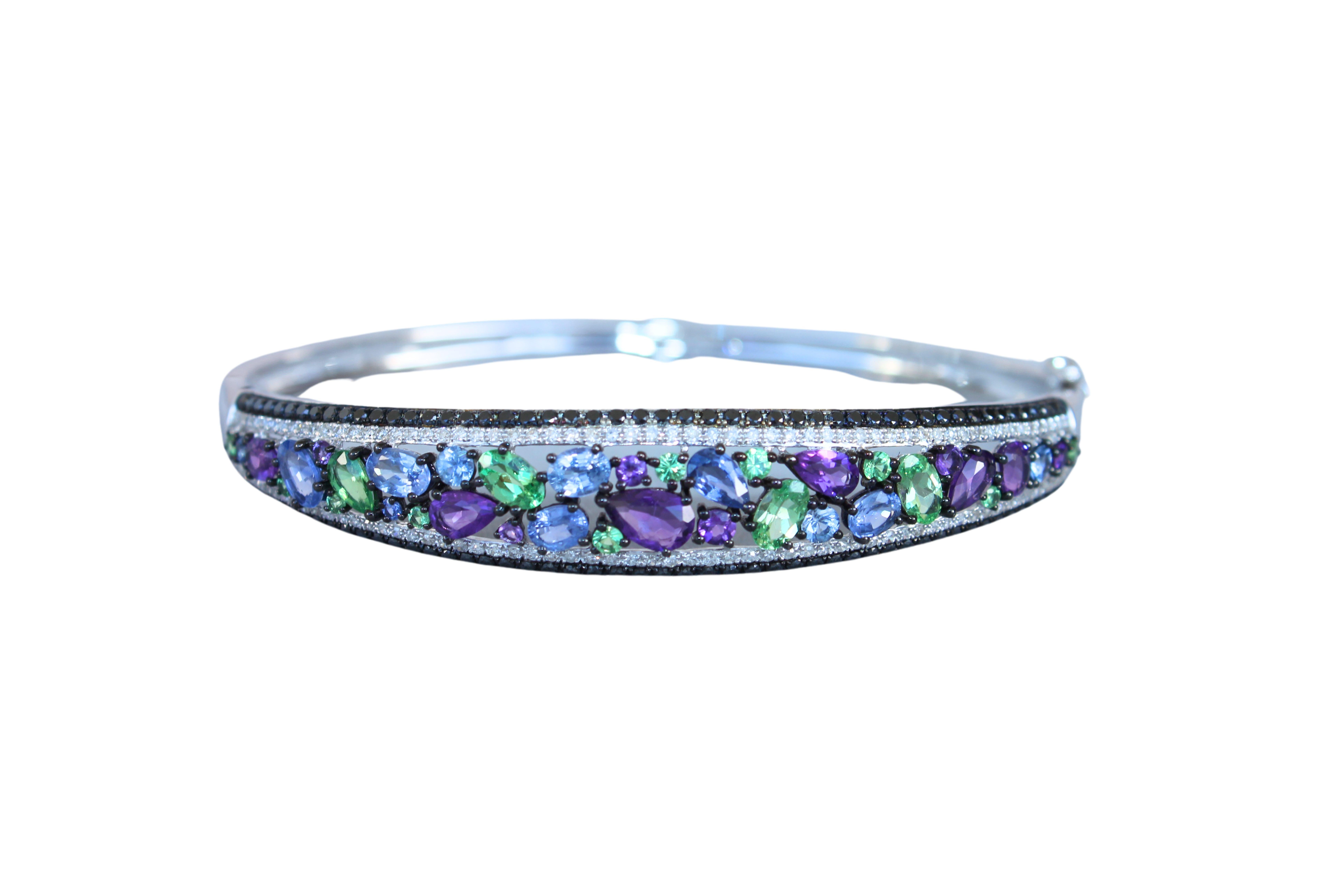 Multi Fancy Shape Multi Color Gemstones (Sapphires, Amethysts, Tsavorites)
5.07 CTW
Round Diamond 1.2 CTW of white & black diamonds
14K White Gold
60 x 50 mm length width ratio of inner dimensions
Will fit most small and medium-size wrists
