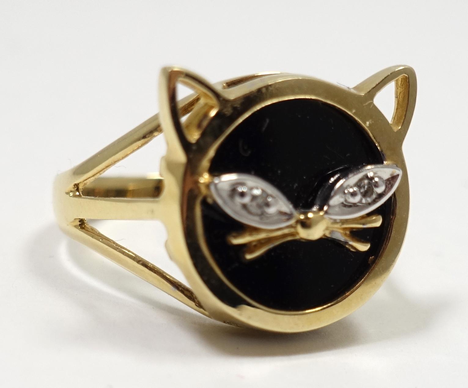 This ring features a cat face design in black onyx with diamond eye accents in a 14kt gold setting, This ring is a size 6.25 and measures 5/8” across the top.  It is in excellent condition.