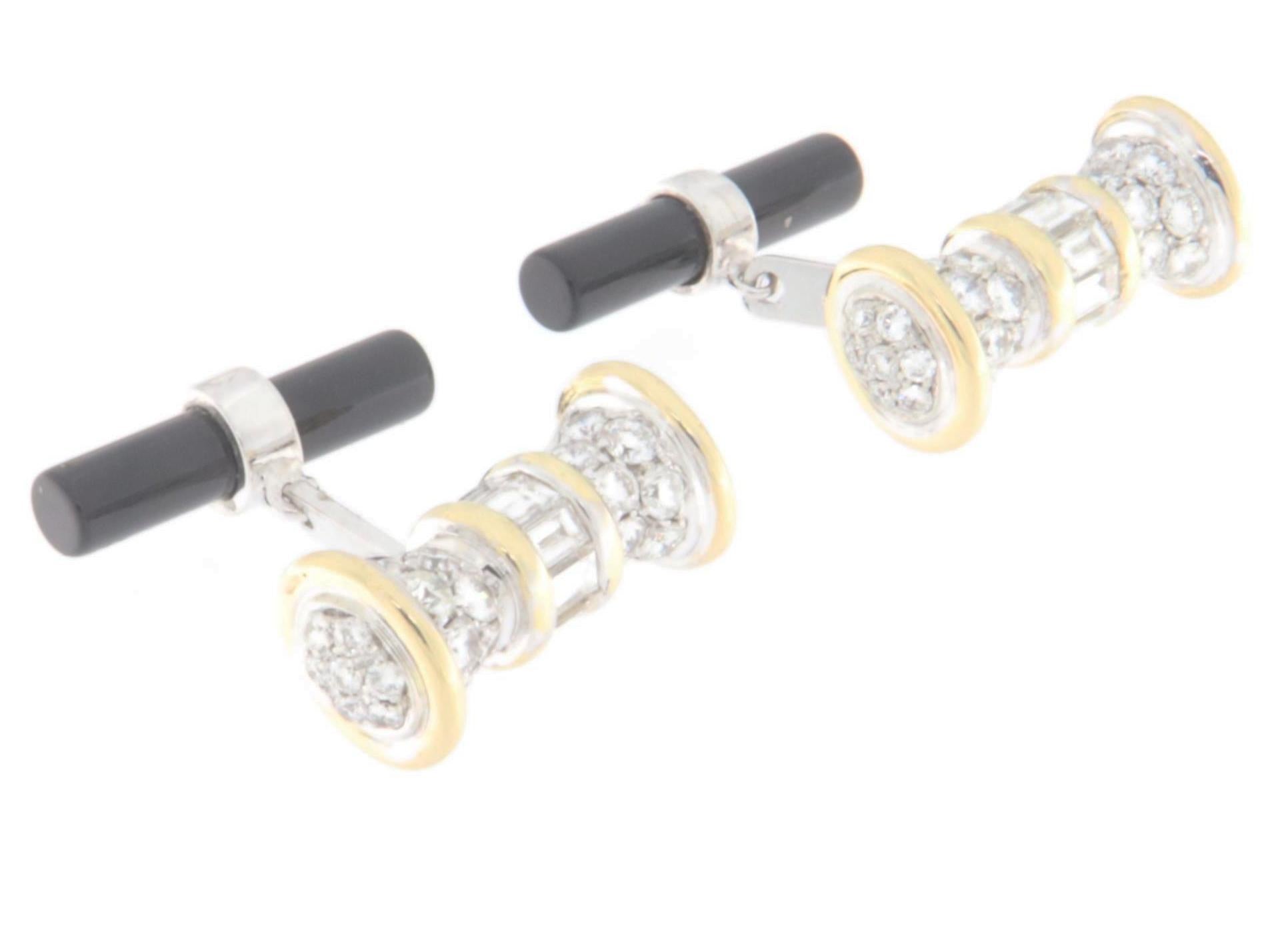 Questi eleganti gemelli sono realizzati in pregiato oro bianco e giallo da 18 carati, che conferisce loro un aspetto raffinato e sofisticato. La struttura è caratterizzata da una lavorazione impeccabile, con il contrasto tra oro bianco e giallo che