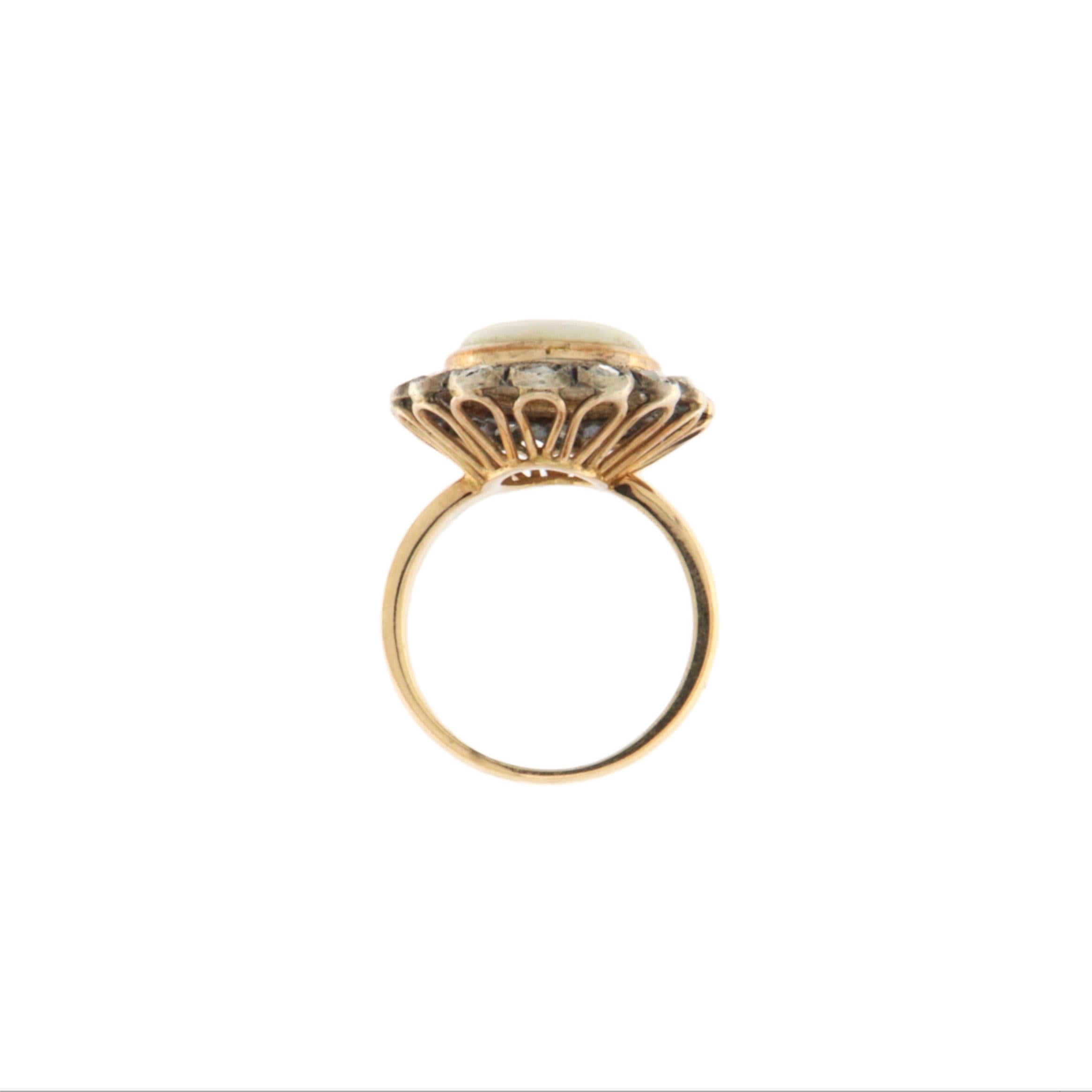 L'élégance intemporelle et le charme vintage se retrouvent dans cette bague exquise réalisée en or jaune 14 carats et en argent 800 millièmes. Au cœur de la pièce se trouve une superbe opale australienne, une pierre précieuse réputée pour son jeu de