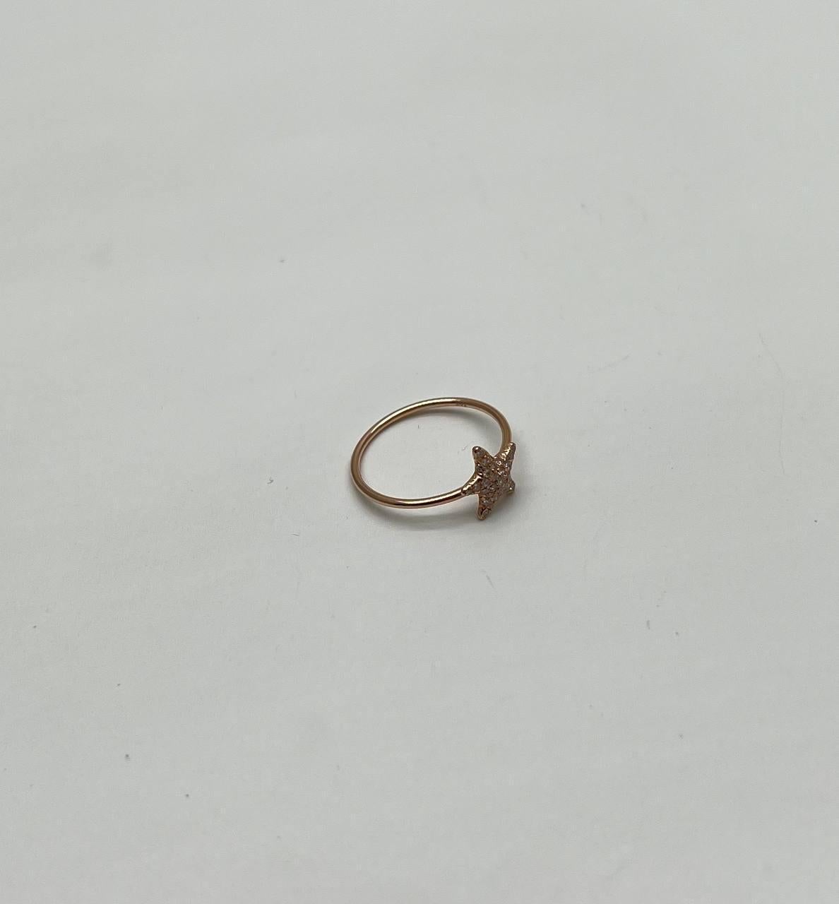 Discover the charm of modern elegance with our exquisite ring. This delicate piece features a slender band adorned with a star-shaped design, encrusted with shimmering diamonds that catch the light beautifully. The minimalist silhouette highlights