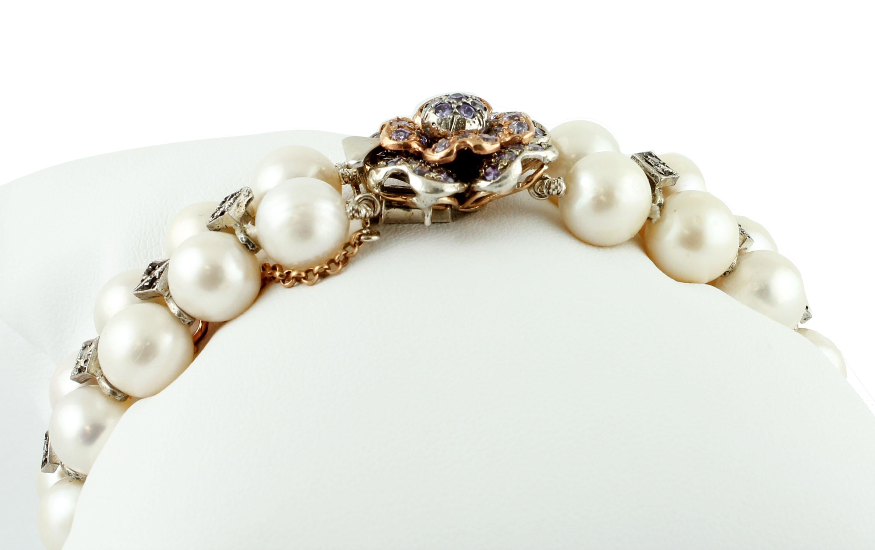 Beautiful beaded bracelet in 9k rose gold and silver structure, realized with two rows of south sea pearls enriched by decorations in silver and diamonds, and a flower-shaped closure in gold and silver structure studded with hard stone. 
The origin