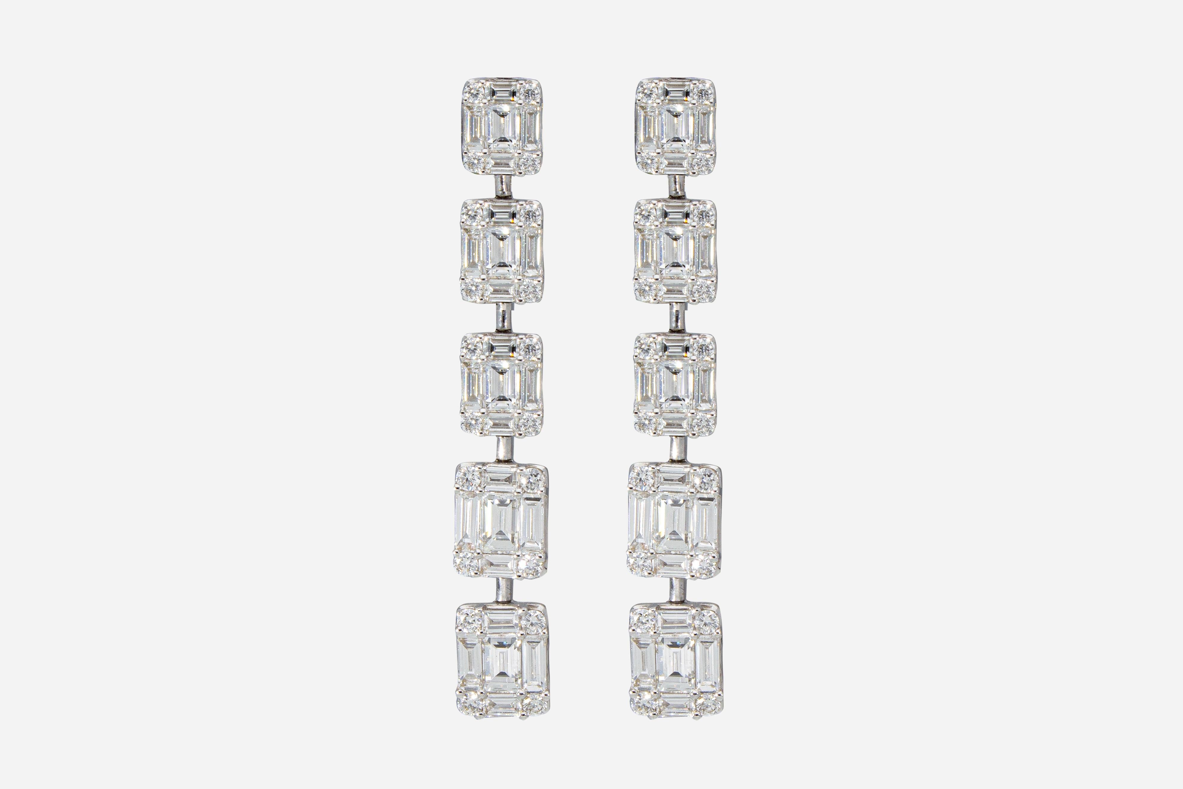 The earrings are made up of 10 graduated rectangular elements. 
Each element is set with 4 brilliant-cut diamonds and 5 baguette-cut diamonds. 
Total number of brilliants: n ° 90 
Total carat weight: 3.65 ct
The earrings are in 18 Kt white gold
The