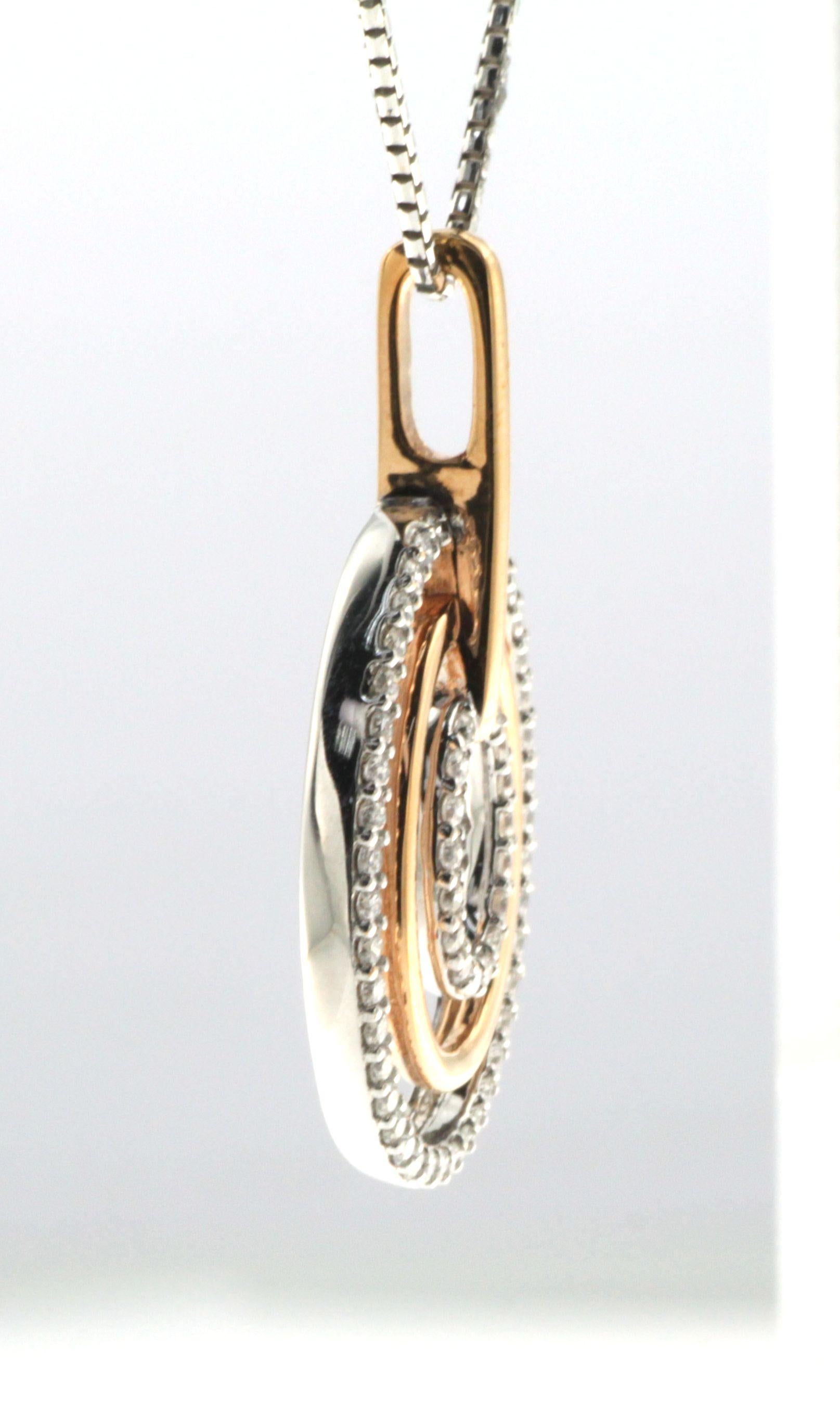 This elegant pendant showcases a timeless design featuring interlocking circles set in a harmonious blend of 18 karat rose and white gold. Accented with 0.58 total carat weight of round brilliant diamonds, the pendant sparkles with every movement,
