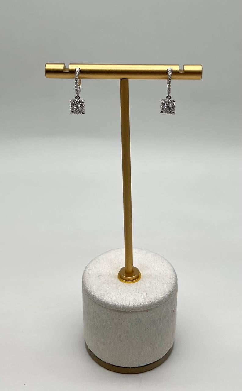 Questo splendido paio di orecchini è realizzato in oro bianco 14 carati. Gli orecchini sono caratterizzati da diamanti bianchi a taglio rotondo, che offrono un brillante scintillio. Il design è elegante e moderno, con una goccia delicata che