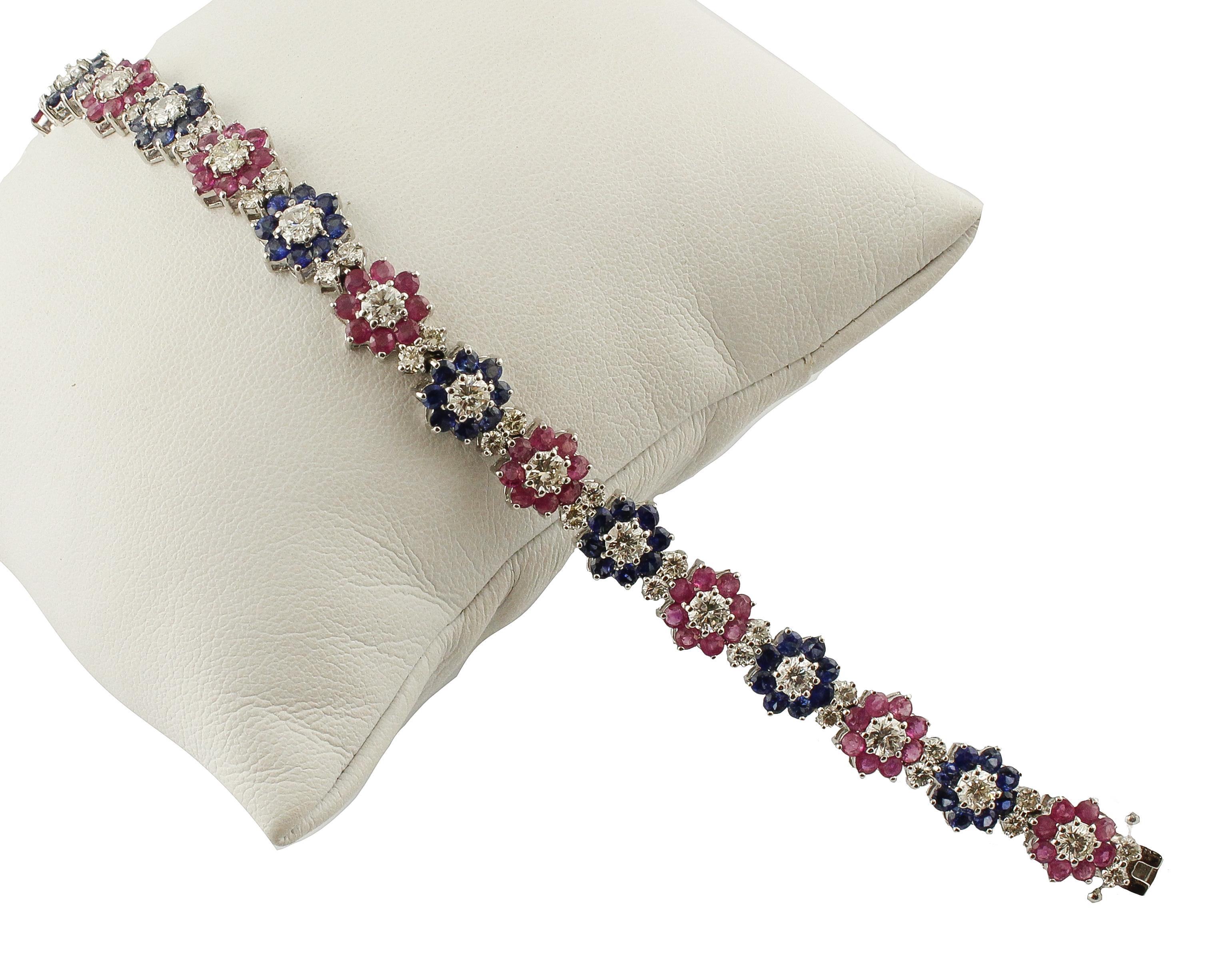 Contemporary link bracelet in 14K white gold composed of diamonds and  blue sapphires flowers altetnating with diamonds and rubies flowers.
Diamonds 5.04 ct(big diamonds 0,20 small diamonds 0.06)
Blue Sapphires and Rubies 9.03 ct 
Total Weight 17.40
