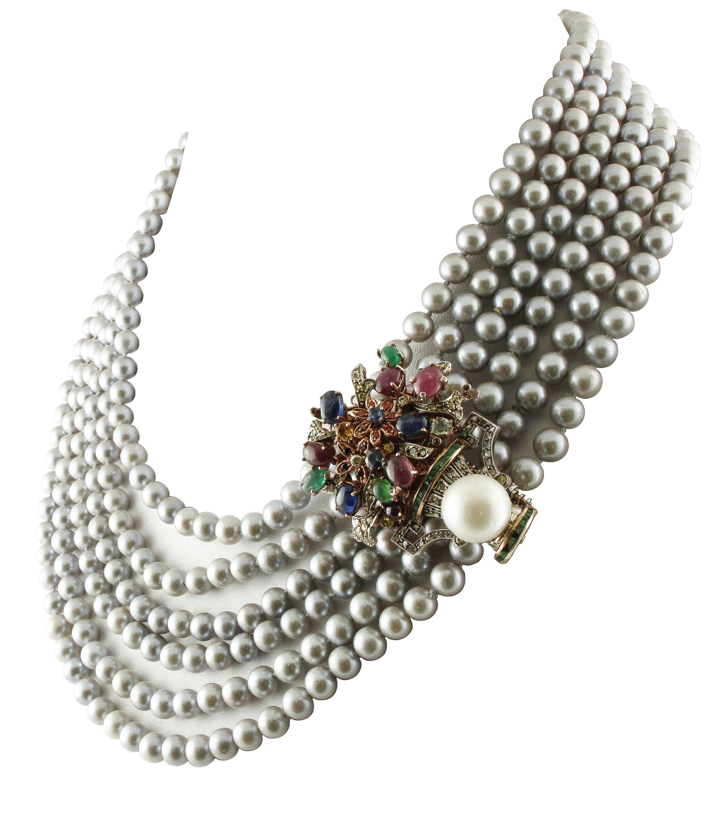 Amazing Multi-strand, beaded necklace composed by six grey pearl rows and flowerpot shape clasp in 9K rose gold and silver, embellished by leaves and flowers detailes and studded by 0.19 ct of diamonds, 10.82 ct of rubies, emeralds, blue, yellow and