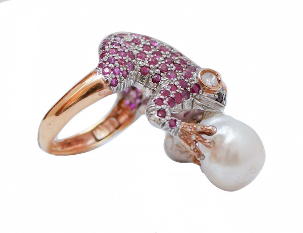 Ring in Froschform aus 9 Karat Roségold und Silberstruktur, vollständig besetzt mit Rubinen und Diamanten auf dem Körper und 2 Diamanten  als Augen. Der Frosch hält eine Perle.
Diamanten 0,37 ct
Rubine 5,47 ct
Perle 2.00 gr 
Gesamtgewicht 11,30