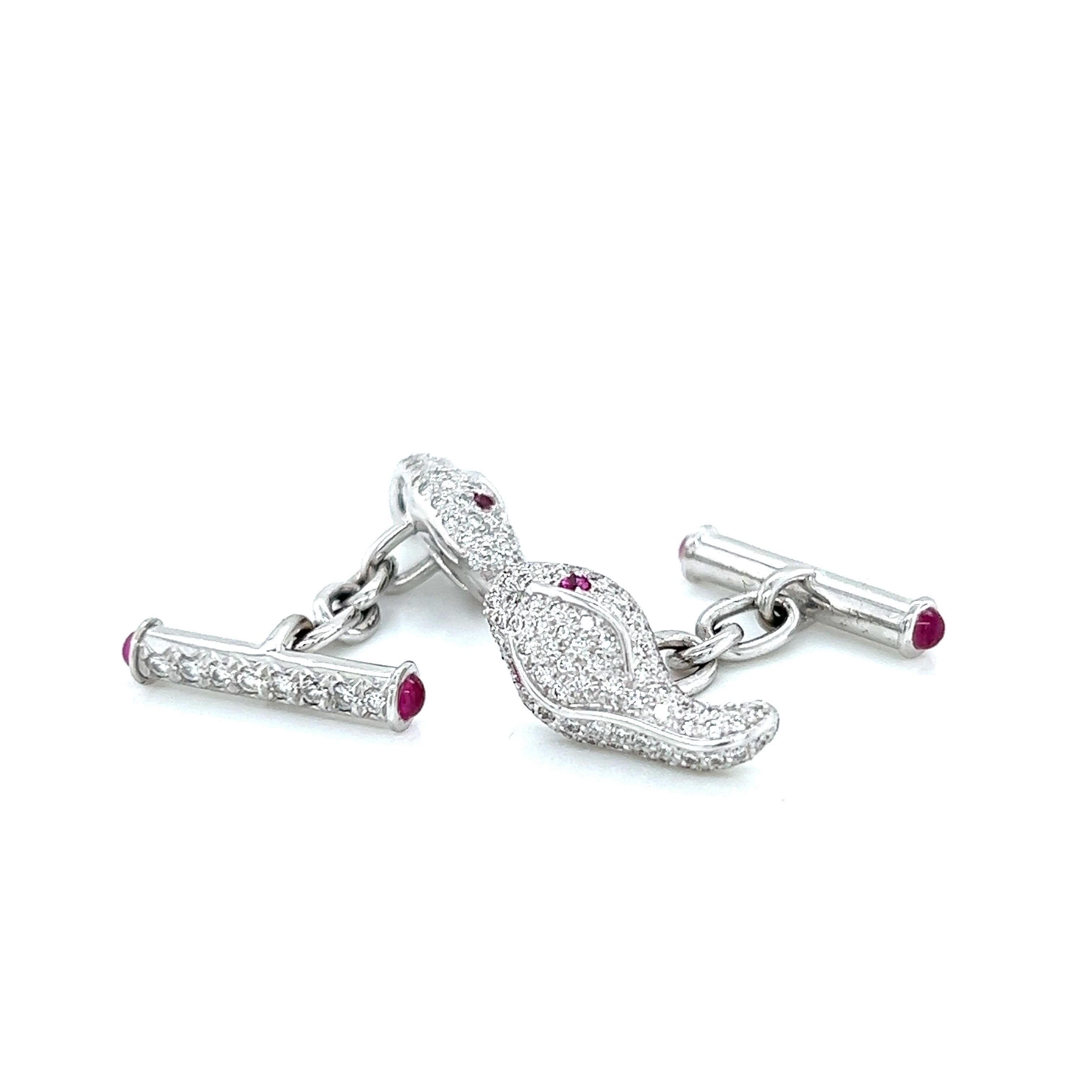 Boutons de manchette en or blanc 18k serpent en diamant, ornés d'yeux hypnotiques en rubis et d'une chaîne les reliant entre eux. Ces boutons de manchette incarnent la combinaison parfaite du luxe et du style, conçus pour attirer l'attention et