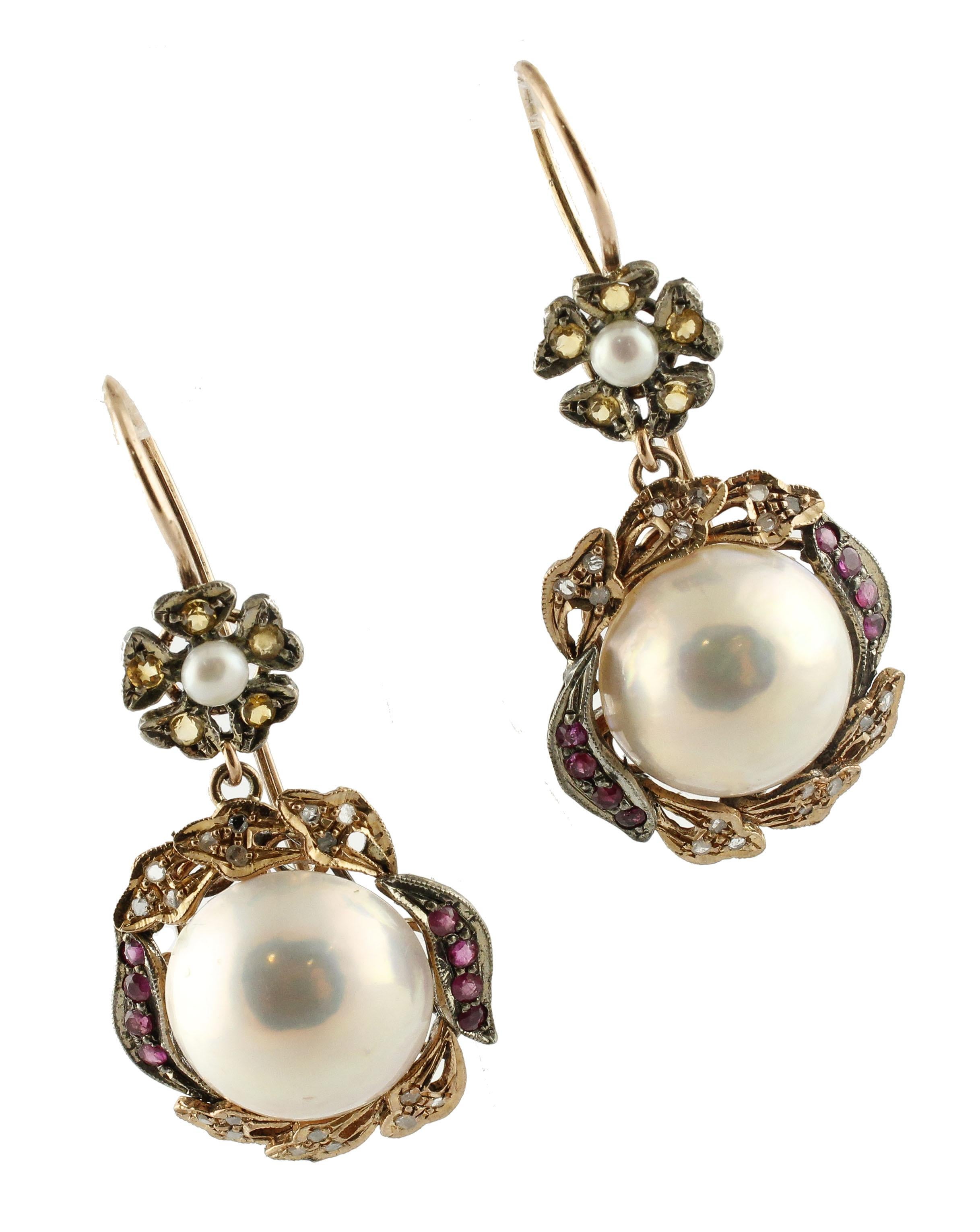Amazing 9K rose gold and silver drop earrings composed of 4.20 g of glossy pearls surrounded by leaves detailes studded by 0.22 ct rose cut diamonds and  rubies and small flowers at the top adorned by  yellow sapphires and small pearls in the