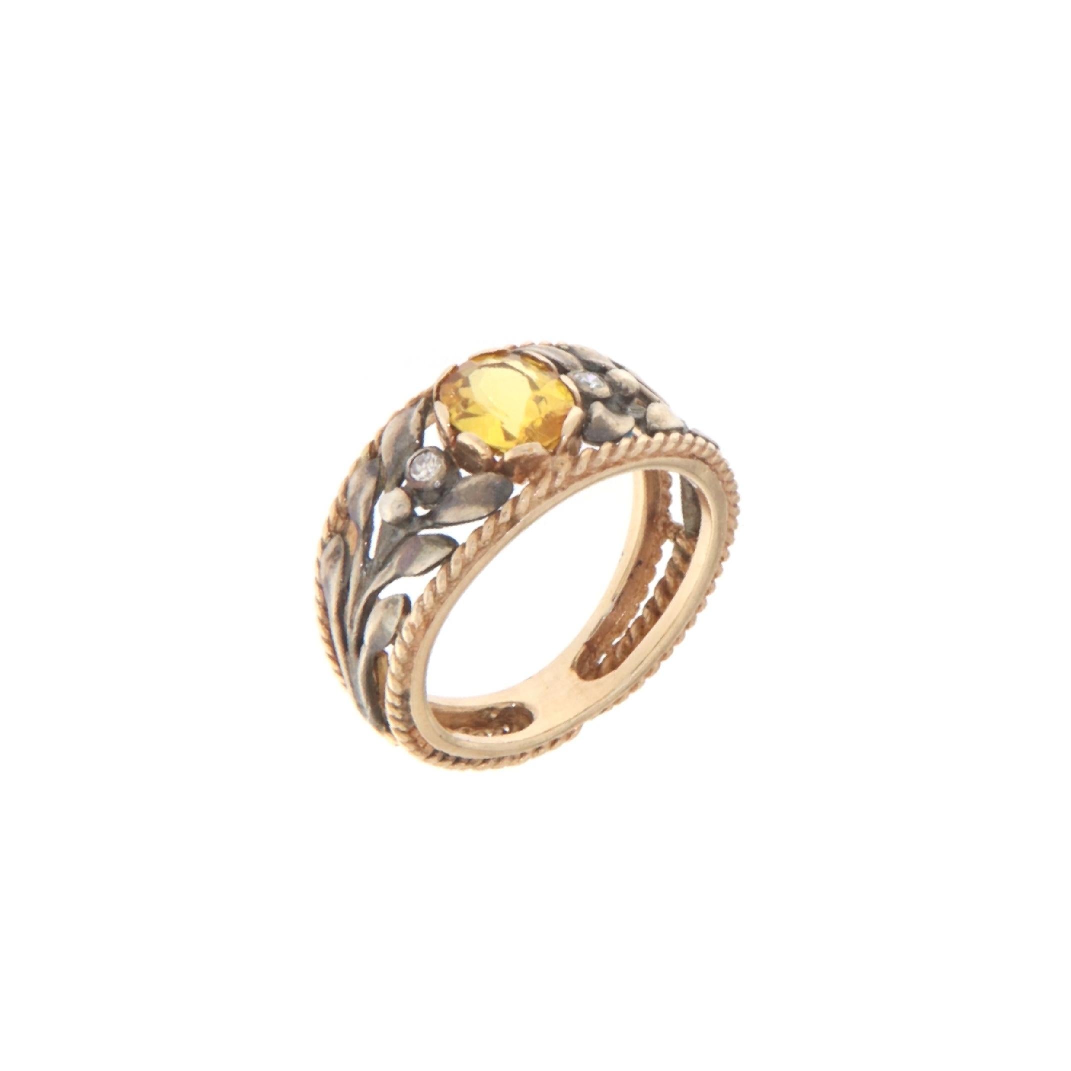 This captivating ring beautifully melds the warmth of 14-karat yellow gold with the luster of 800 silver, presenting a design that’s both traditional and contemporary. The centerpiece is a radiant yellow sapphire, its golden hue reminiscent of the