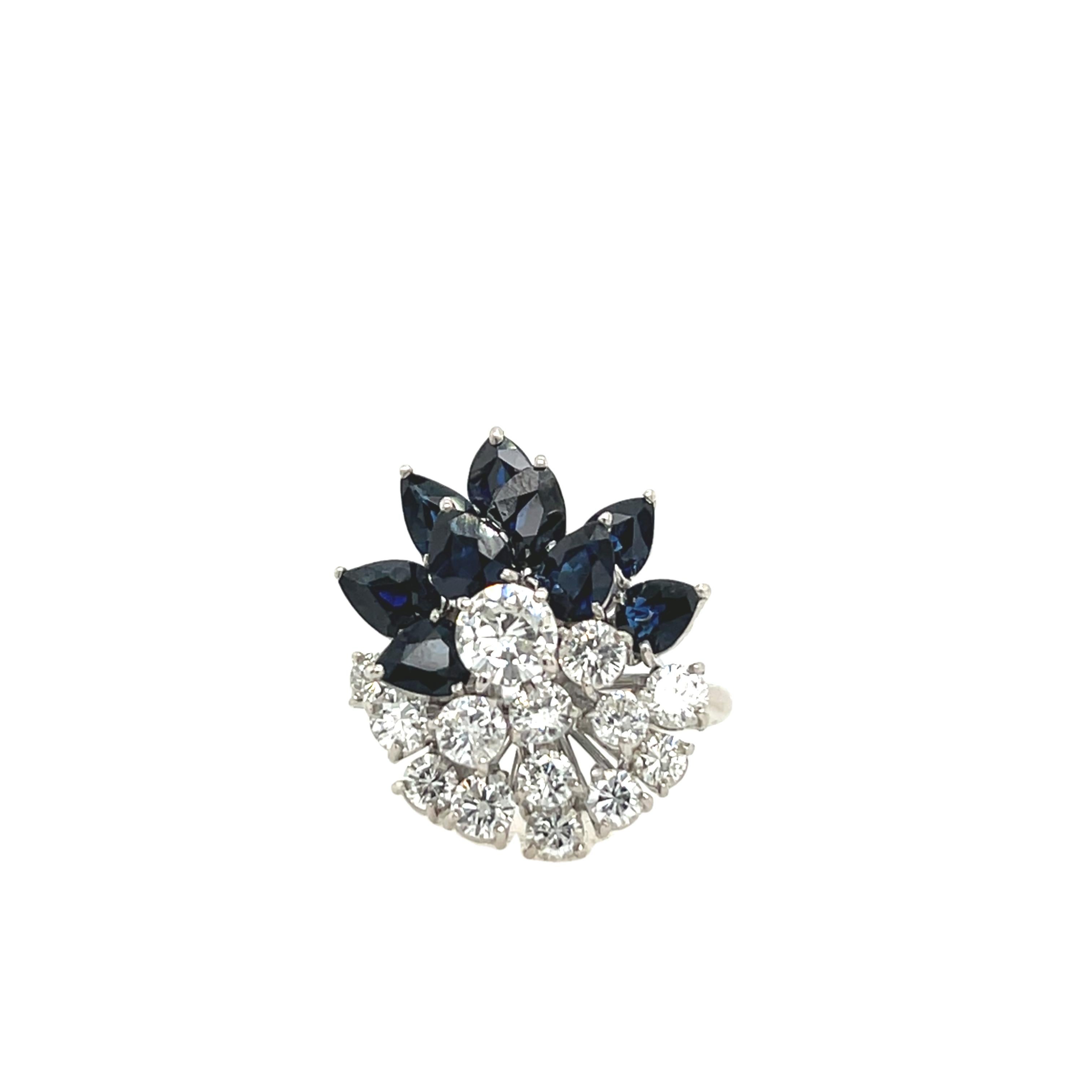 Ein exquisiter Ring aus 18-karätigem Weißgold mit einer schillernden Reihe von runden Diamanten von 1,20 Karat, umgeben von 9 birnenförmigen natürlichen Saphiren. Dieses zeitlose Schmuckstück verbindet die Brillanz von Diamanten mit den satten