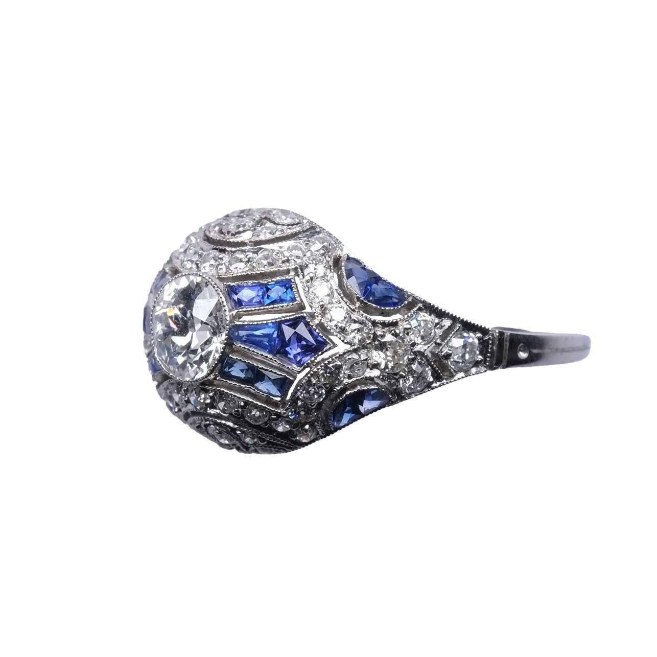 Beautiful ring set in platinum with fine lace like design, with calibrated natural sapphires and old cut diamonds for circa 2.5ct total.

Highlights
- Central diamond 0.65ct
- Total 2.5ct diamonds circa
- Natural sapphires
- Platinum
