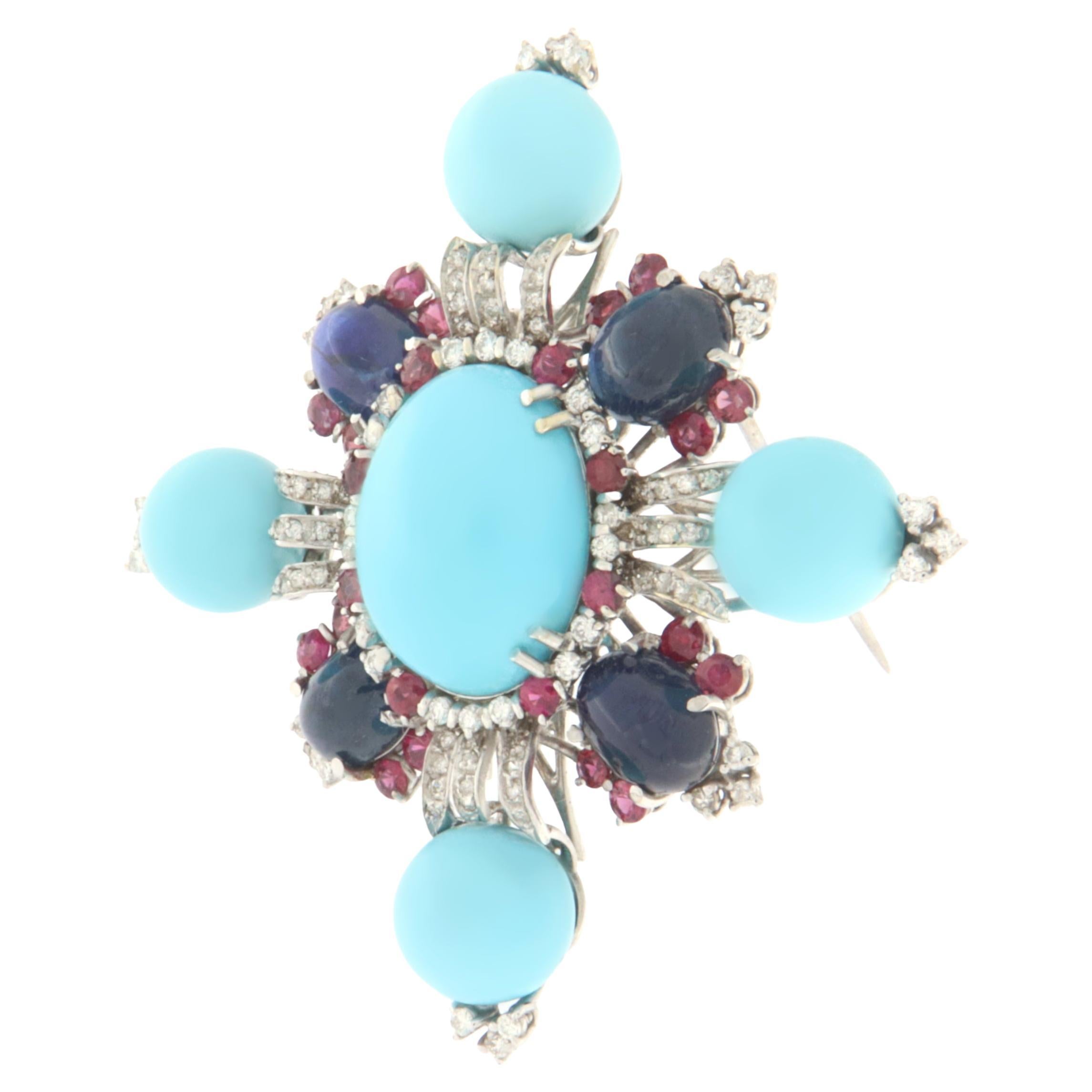 Splendid brooch designed first and then handcrafted by expert artisans in the sector, made of 18-karat white gold and set with natural diamonds, cabochon-shaped sapphires, rubies and turquoise spheres with an oval in the center also of natural