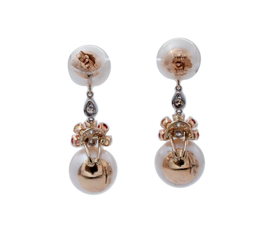 Vintage dangle earrings in 14 kt white and yellow gold structure, mounted with 2 south sea pearls and fine decorations of diamonds and multicolor sapphires.
The origin of these earrings dates back to the 1980s, they are totally handmade by Italian