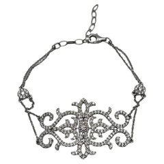 Bracelet fantaisie en or blanc 18 carats orné de symboles de volutes et d'emblèmes en diamants