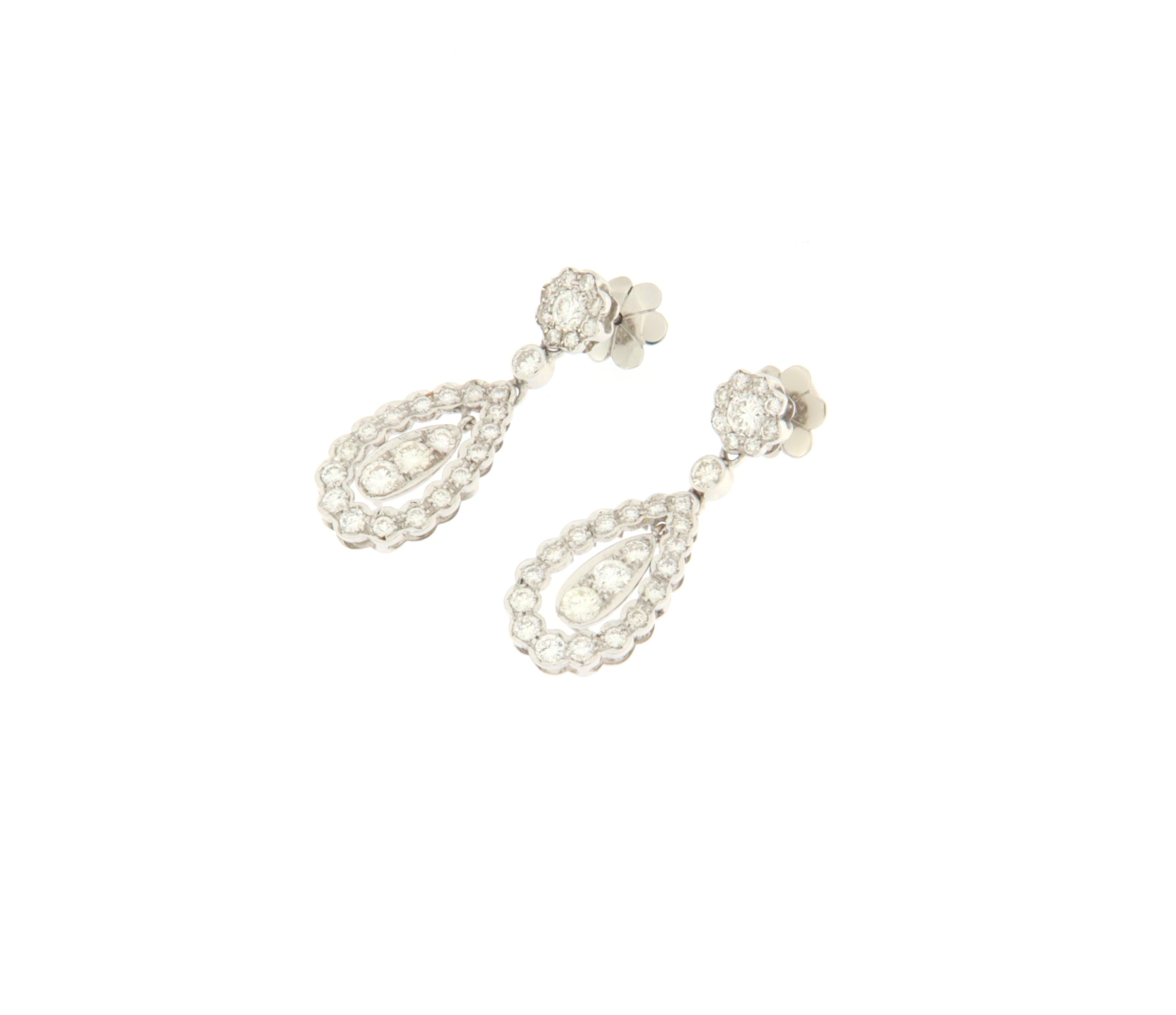 Delicious drop-shaped earring made entirely by hand. In the upper part a small plane depicting a daisy supports two drops, inside the larger drop there is a small mobile drop. On the earrings made of 18K white gold there are natural diamonds of