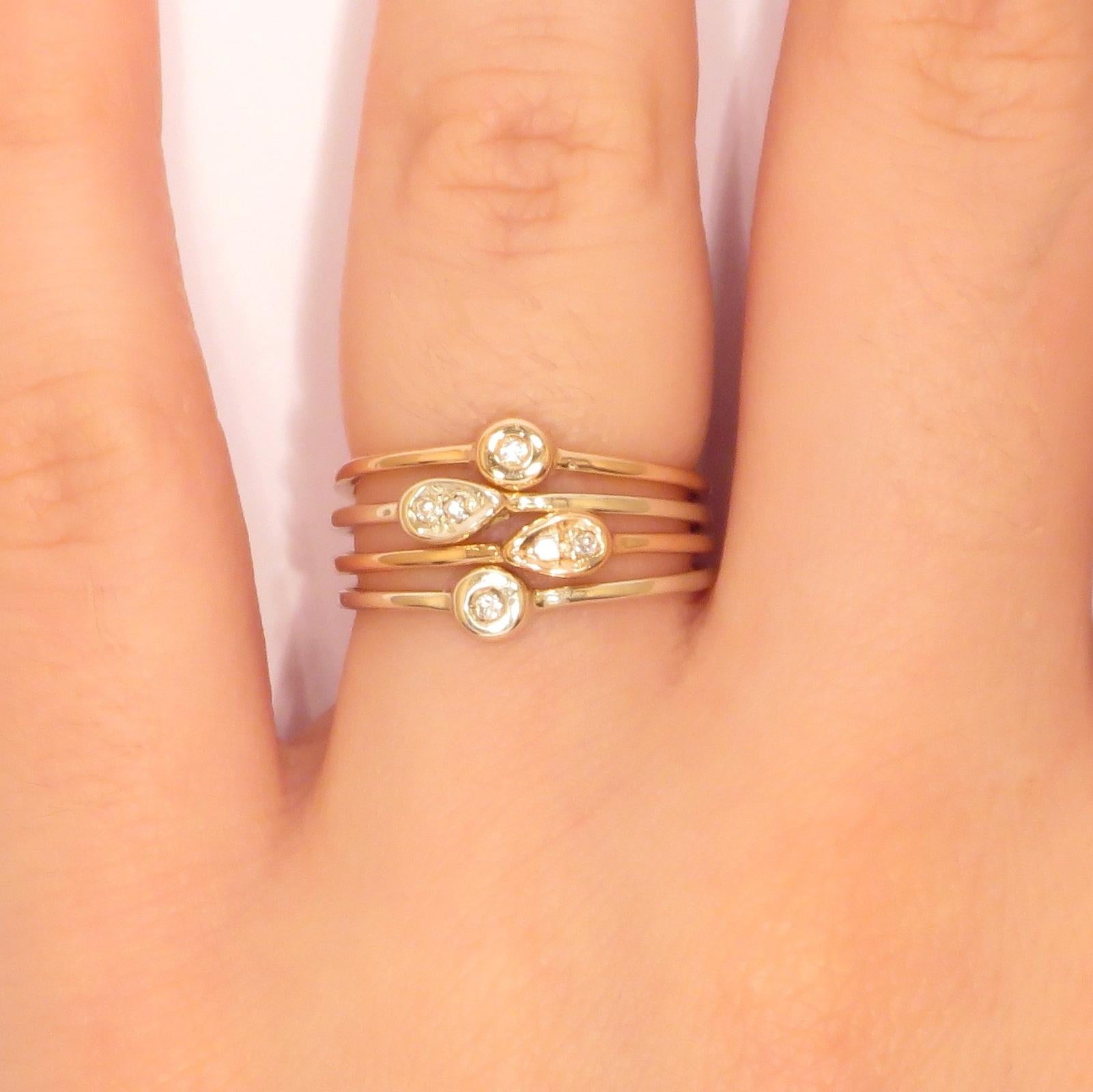 Modern stacking rings in 9 karat white and rose gold with natural round cut white diamonds. The price of this item is for four stacking rings and it is composed by four rings with 2 drops with diamonds and  2 round diamonds.
US finger size is 6,